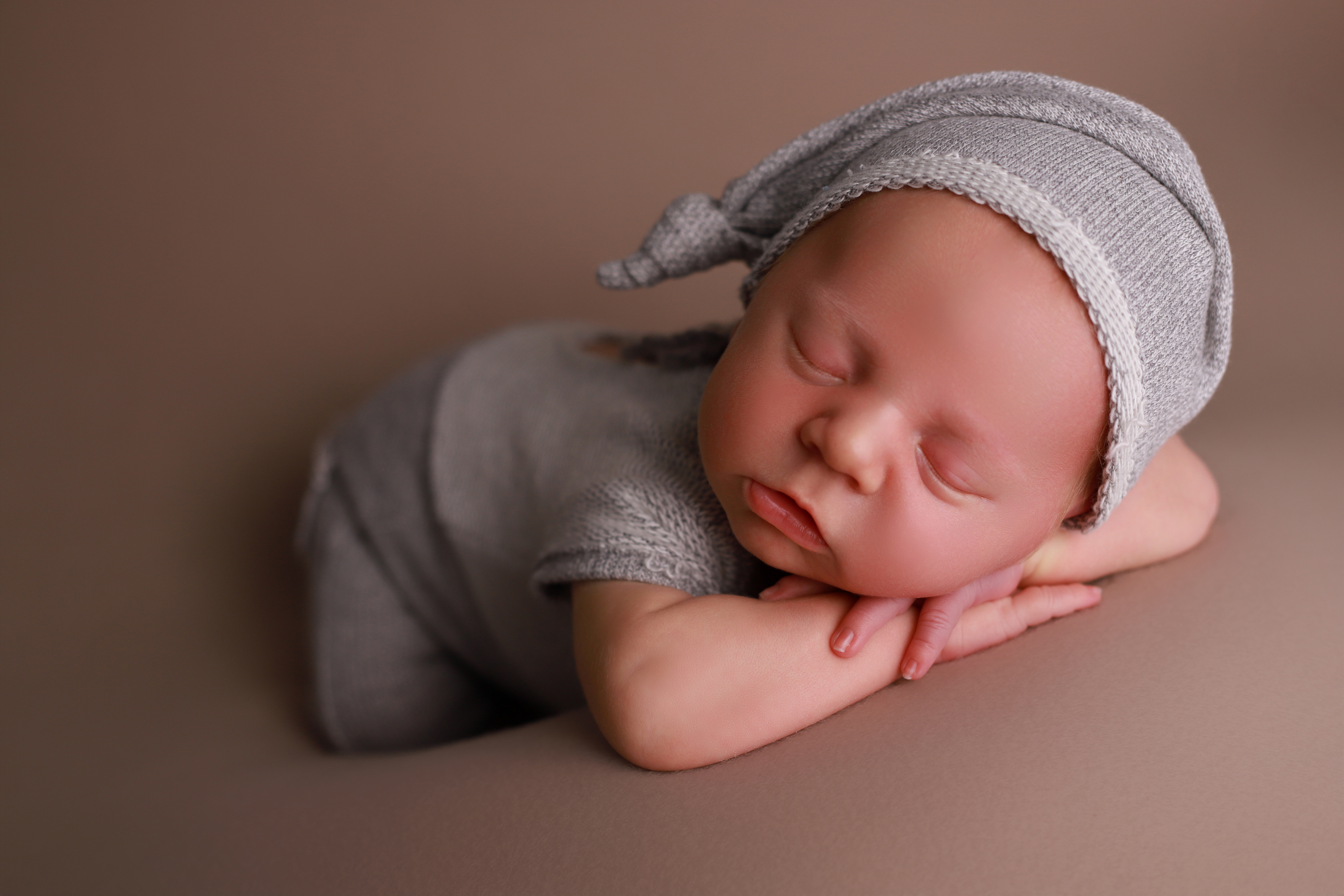 Schlafendes Neugeborenes in einer Chinnypose - Babyhooting in Pforzheim