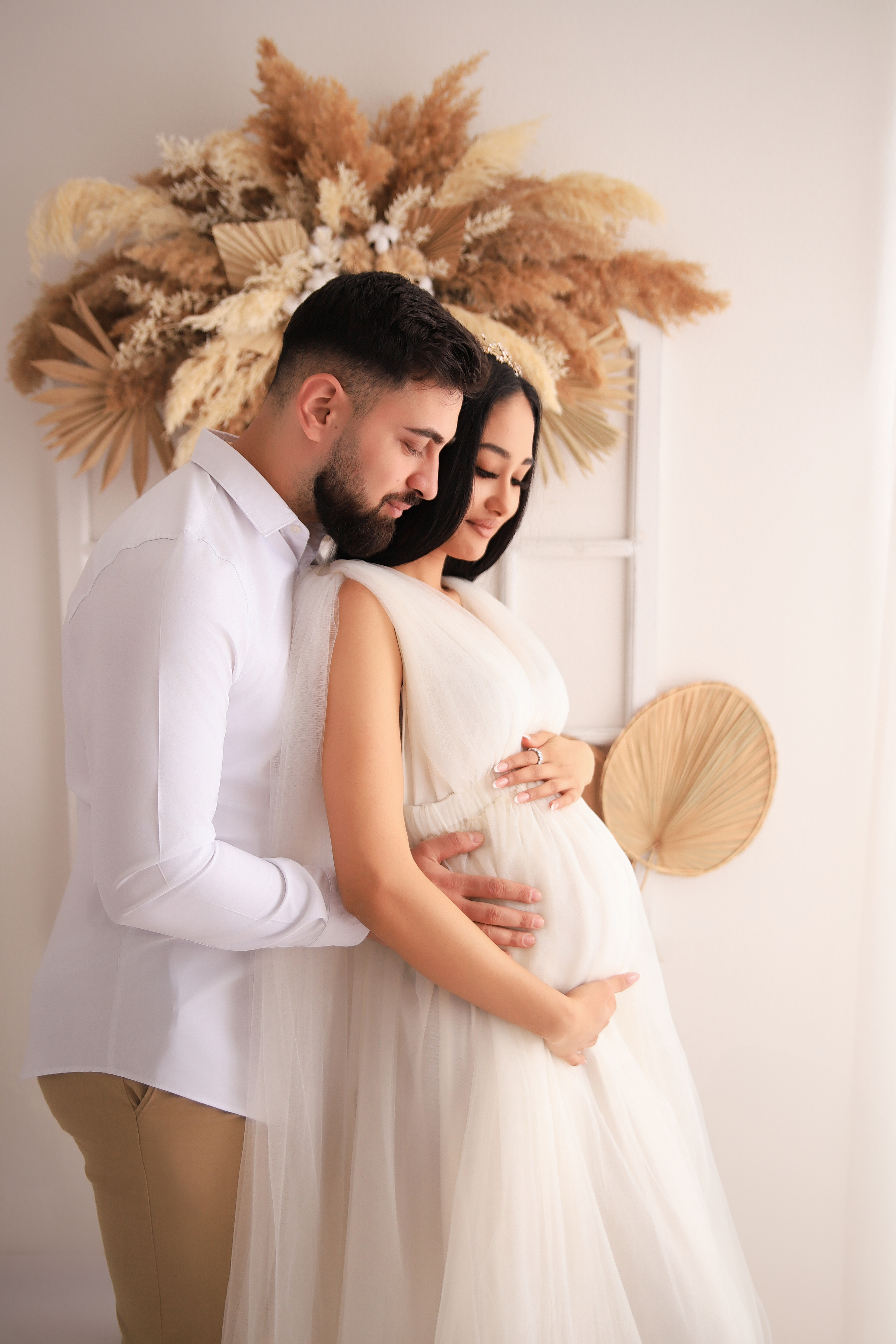 Paar umarmt sich liebevoll bei einem Babybauchshooting