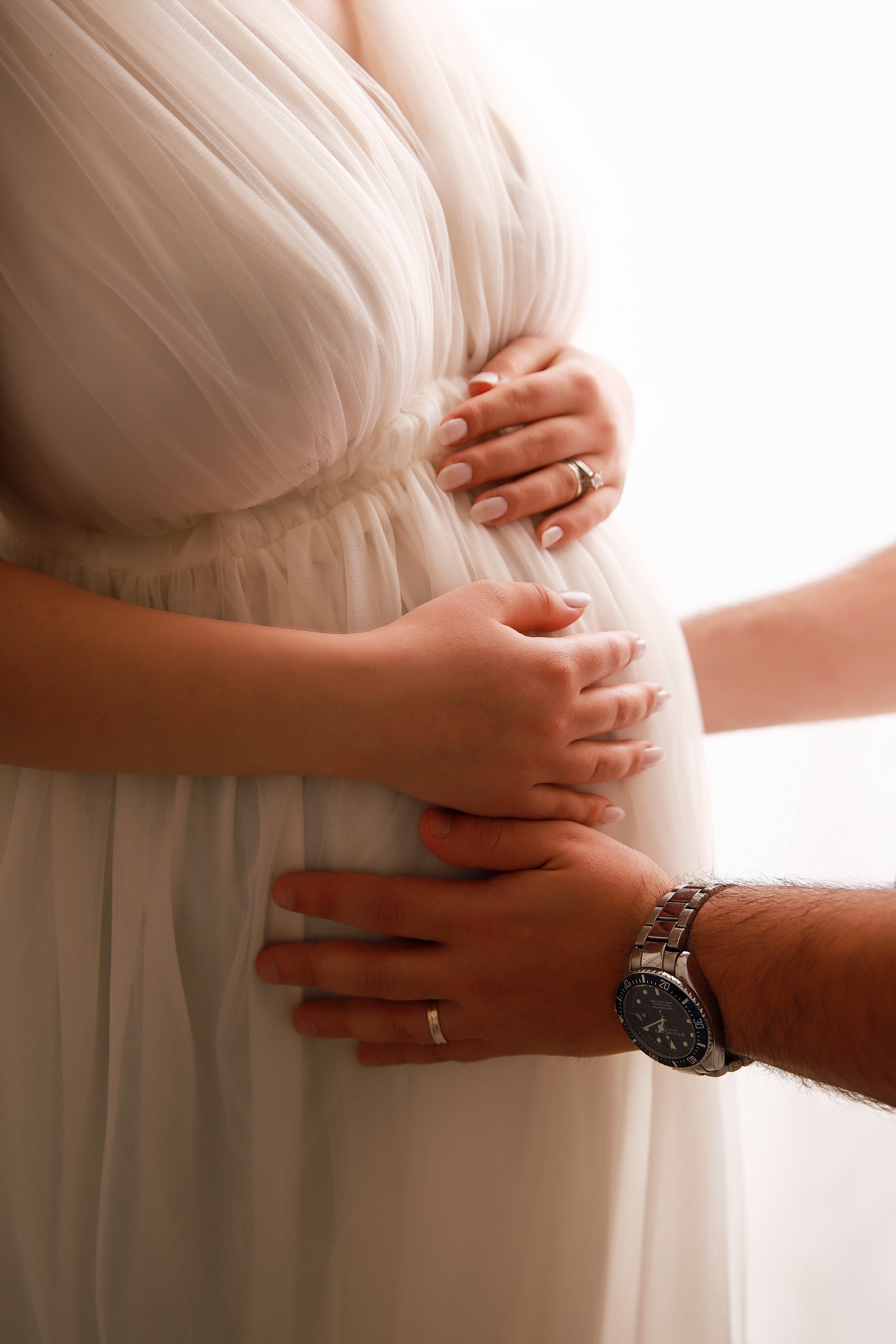Babybauchsilhouette in einem weißen Kleid