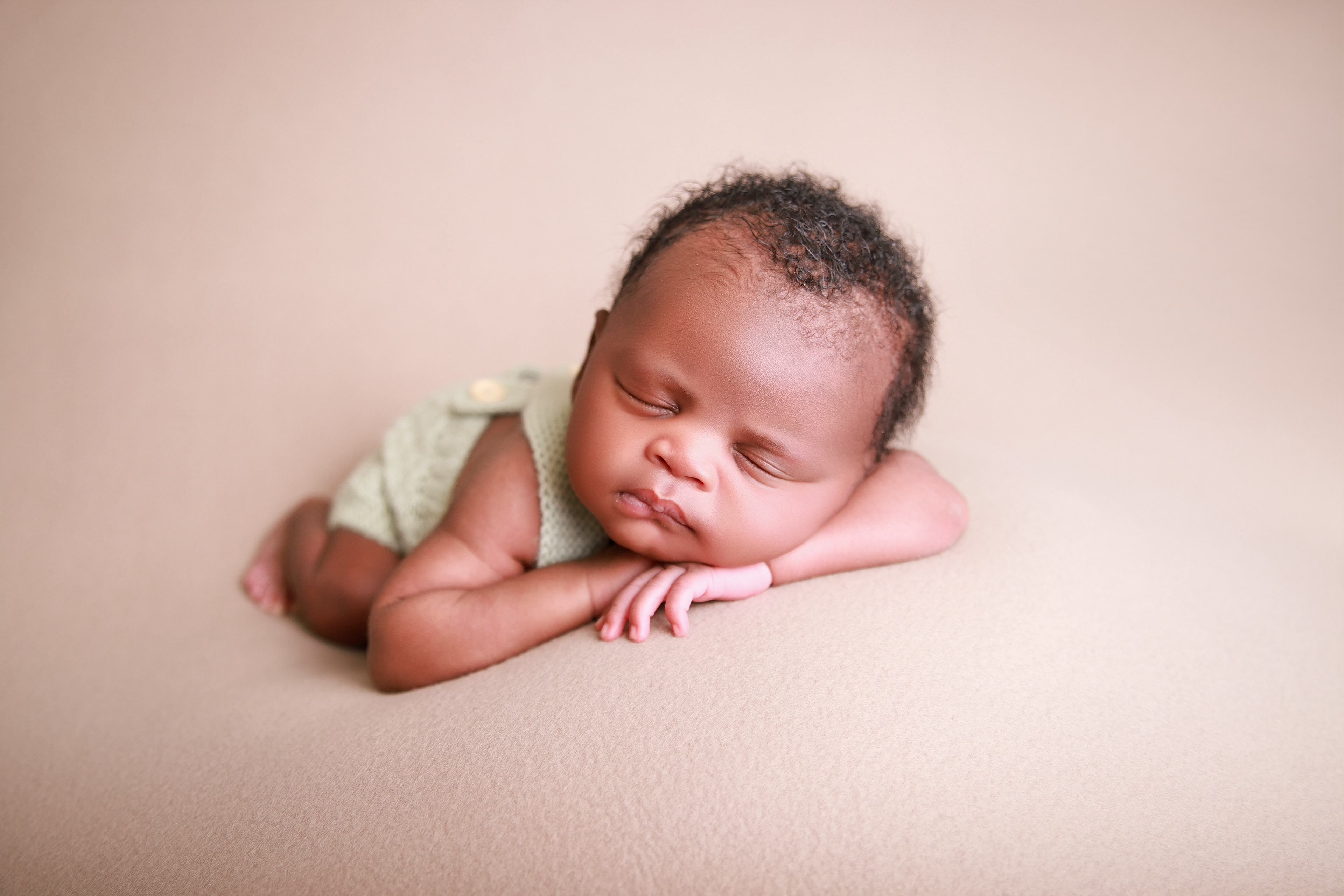 Schlafendes Neugeborenes in einer Chinnypose - Babyhooting in Pforzheim