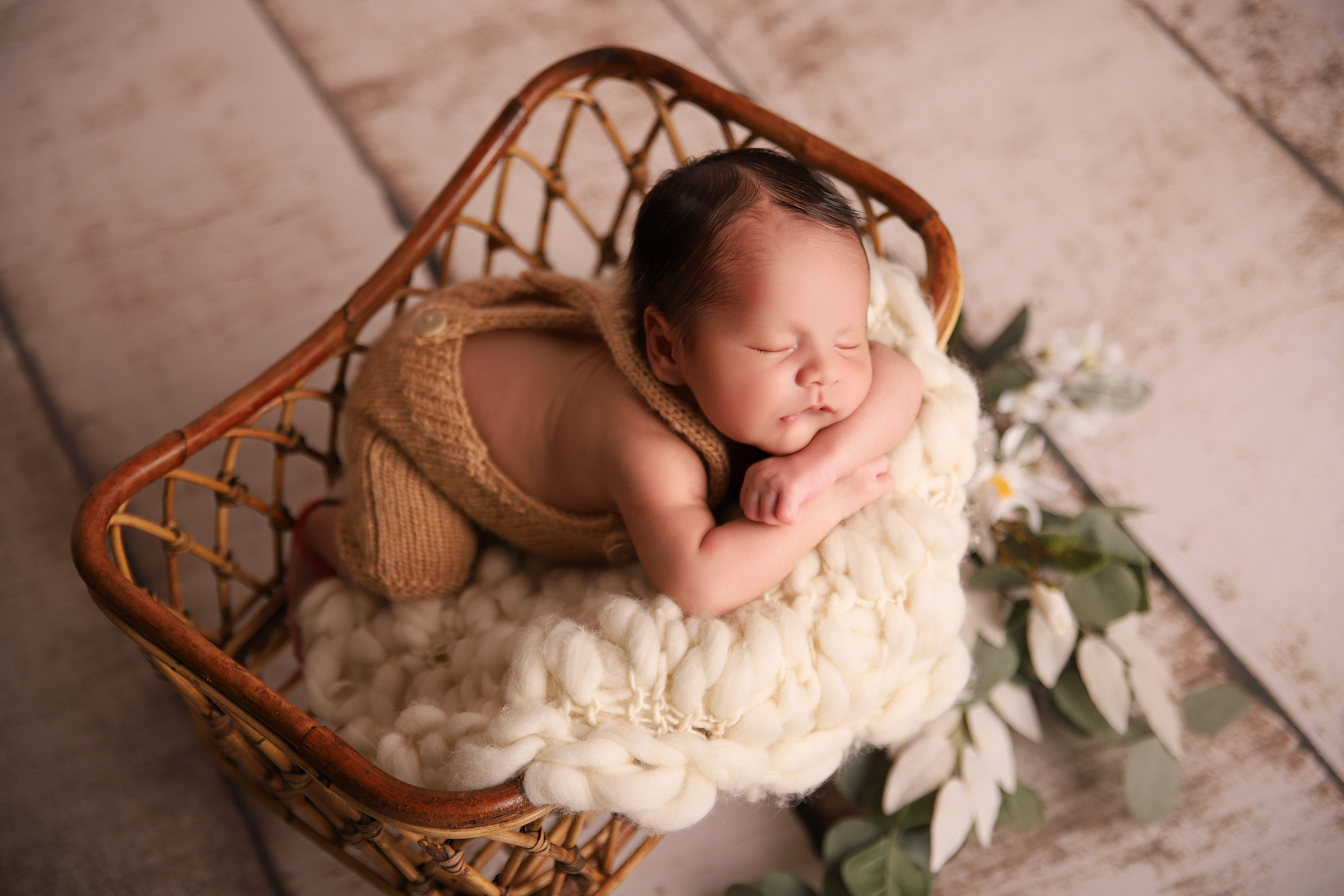 schlafendes Baby in einem Rattanbett - Newbornshooting