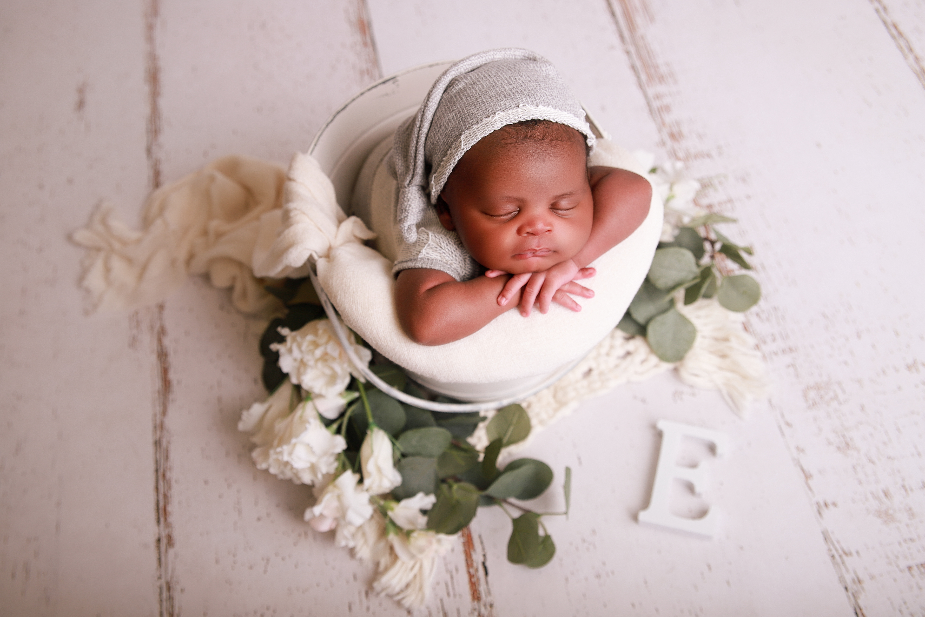 Schlafendes Neugeborenes in einer Eimerpose - Babybshooting in Pforzheim