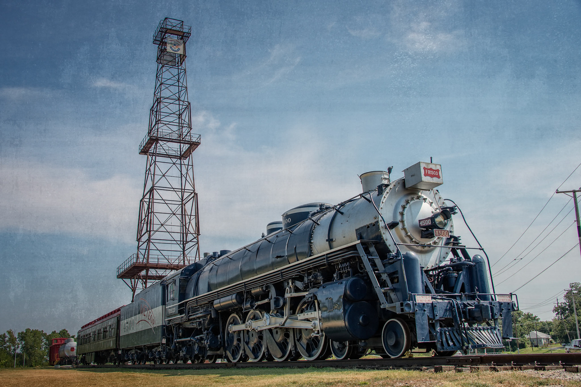 Route 66 Historical Village is an attraction along Old Route 66 in Tulsa, Oklahoma. When visiting in August, 2015, it displayed a restored Frisco 4500 Steam Engine and other restored rail cars, as well as a centennial oil derrick and historic pump jack.