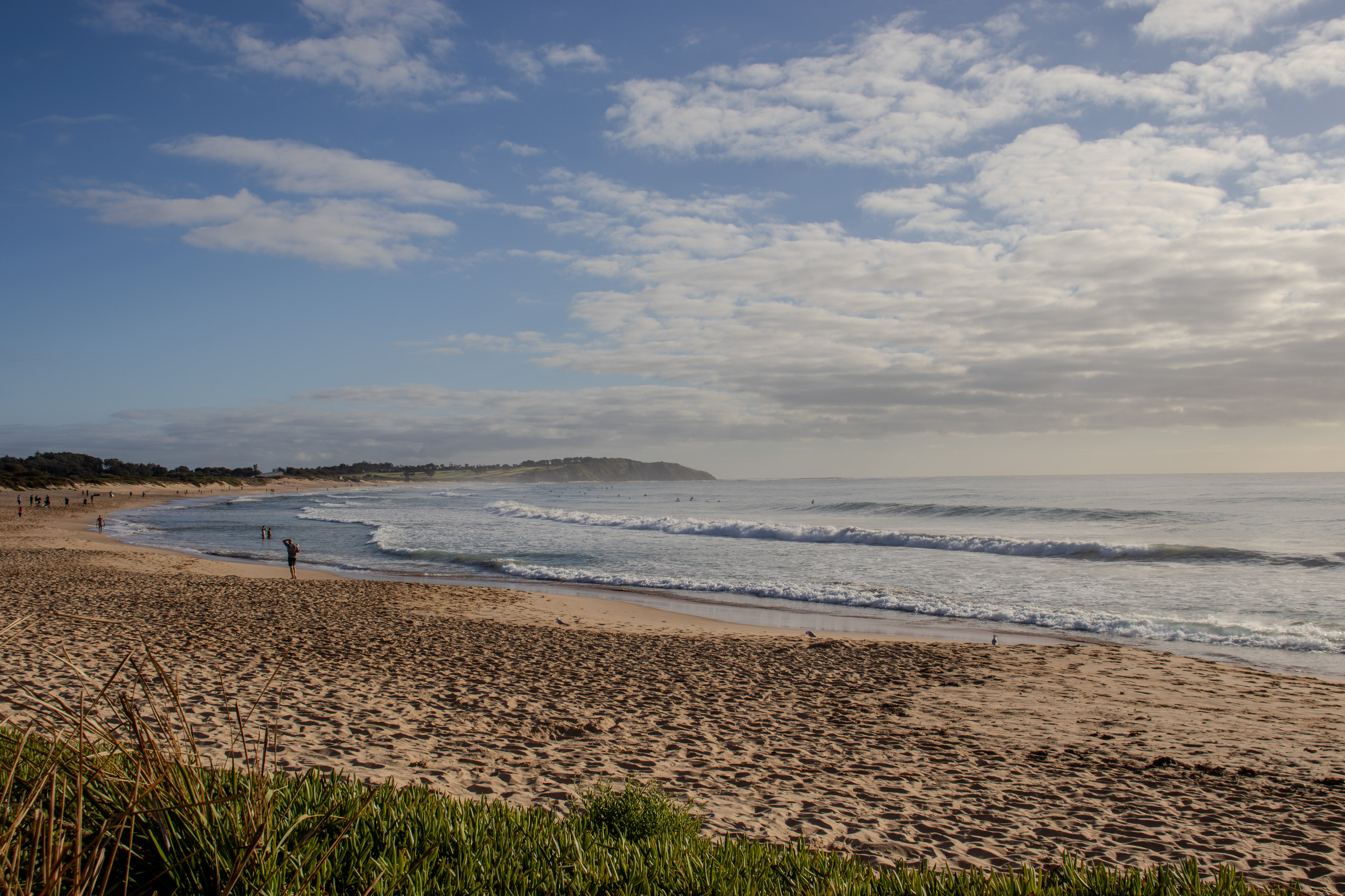 Beach with a cliff edge in the far background of the scene