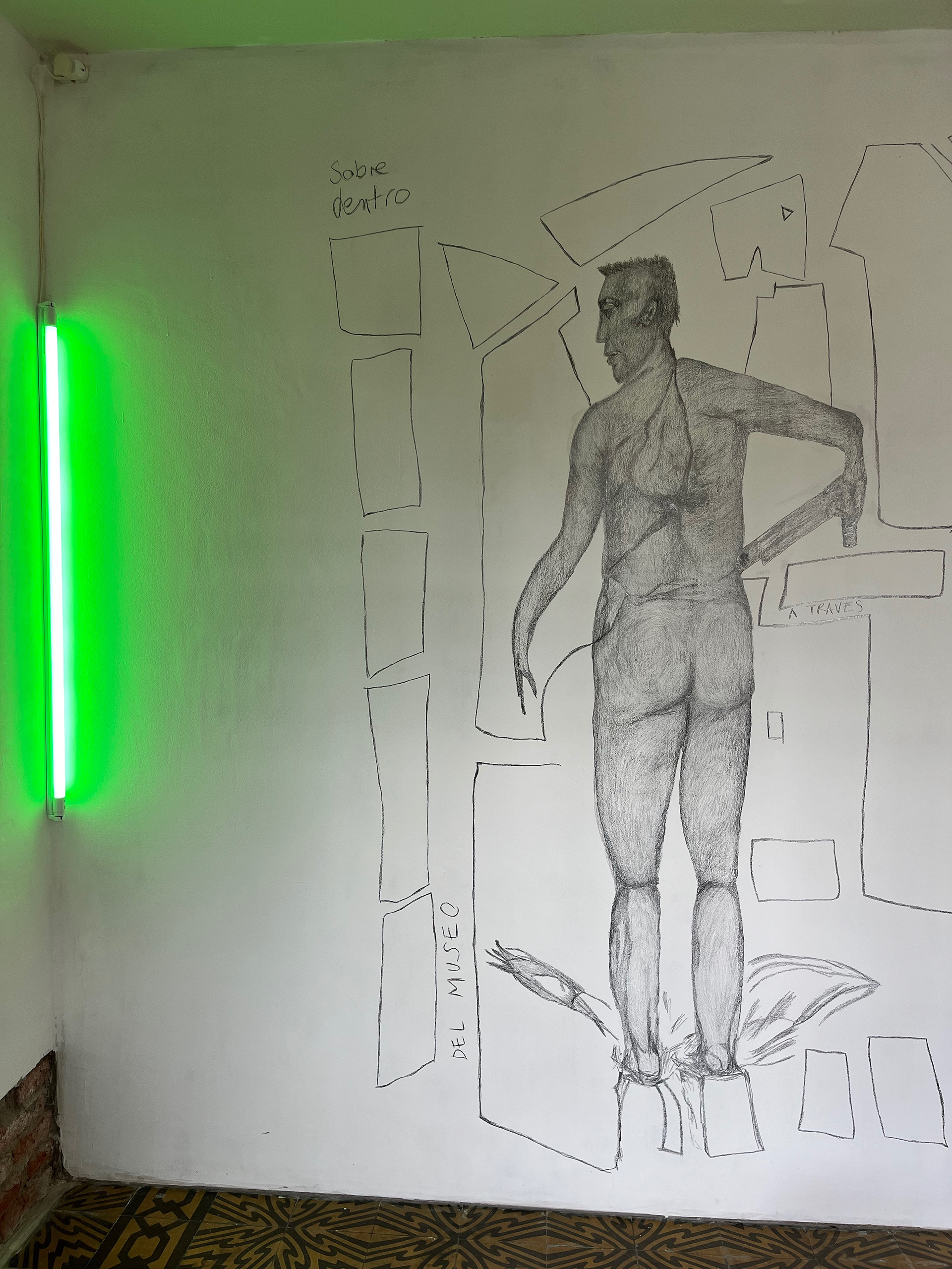 De la serie Narcoafectividades. D. B. C. frente a un ventanal de vidrio con una AK47 de juguete en el MACBA. Transferencia de dibujo a pared 2 x 3 mts. Original: lápiz sobre papel. 14,8 x 21 cm, 2014. Barcelona. Galeria La Arte Contemporánea, Salta, 2024