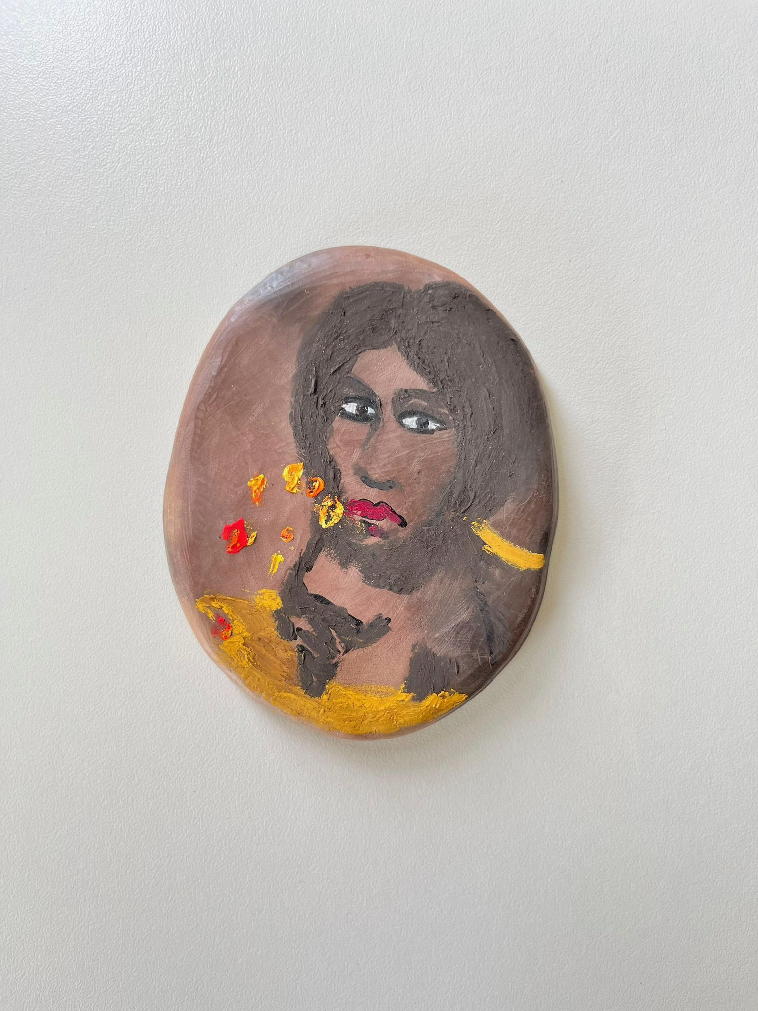 Relicario de Isidora Morales, encontrado en el camino entre Aguaray y Santa Rosa del Aguaray (2024). Óleo sobre arcilla cocida a leña y estampa de fruto de barro cocido. 8 x 8 cm.