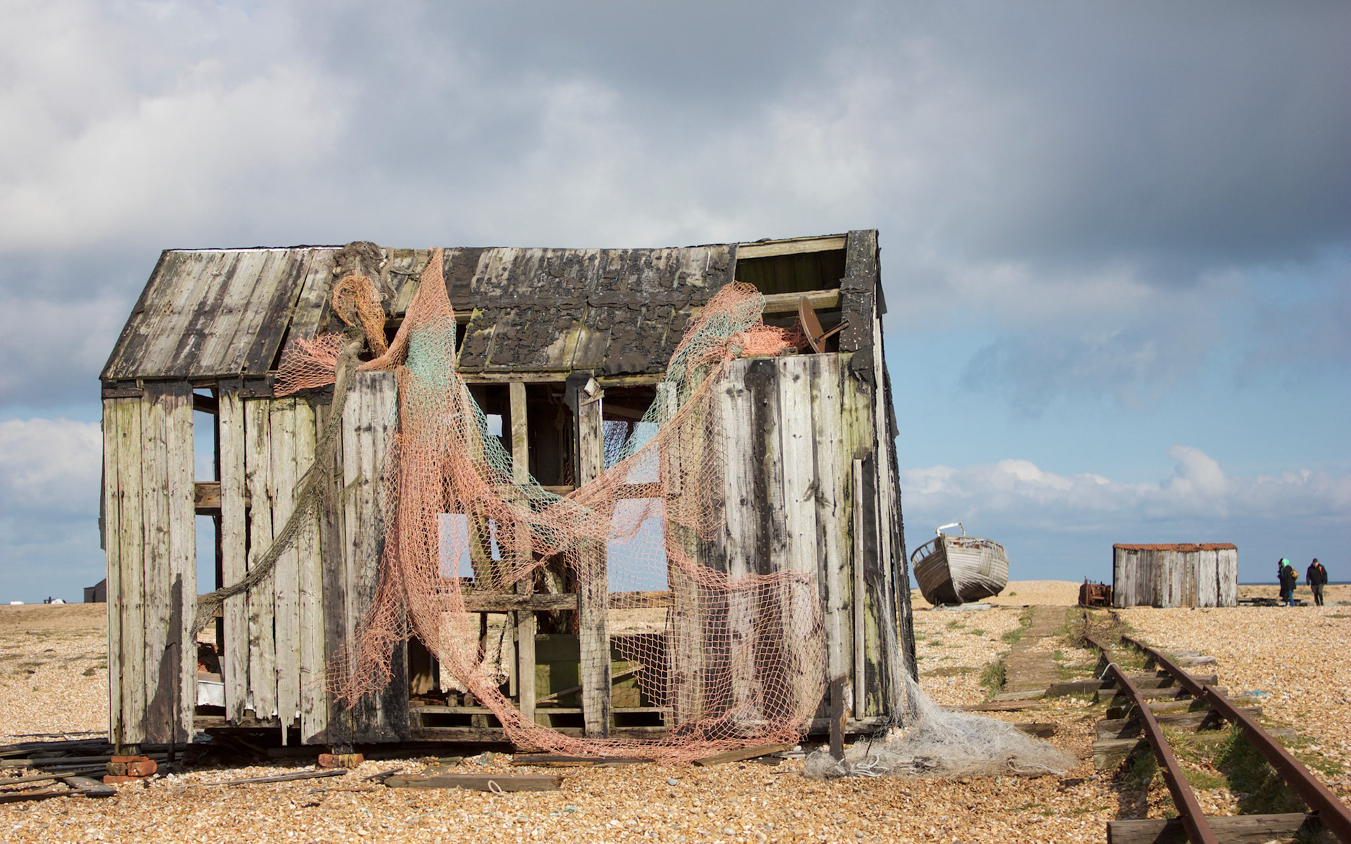Old fishing hut on the beach at Dungeness with old unused railway lines runng down the side