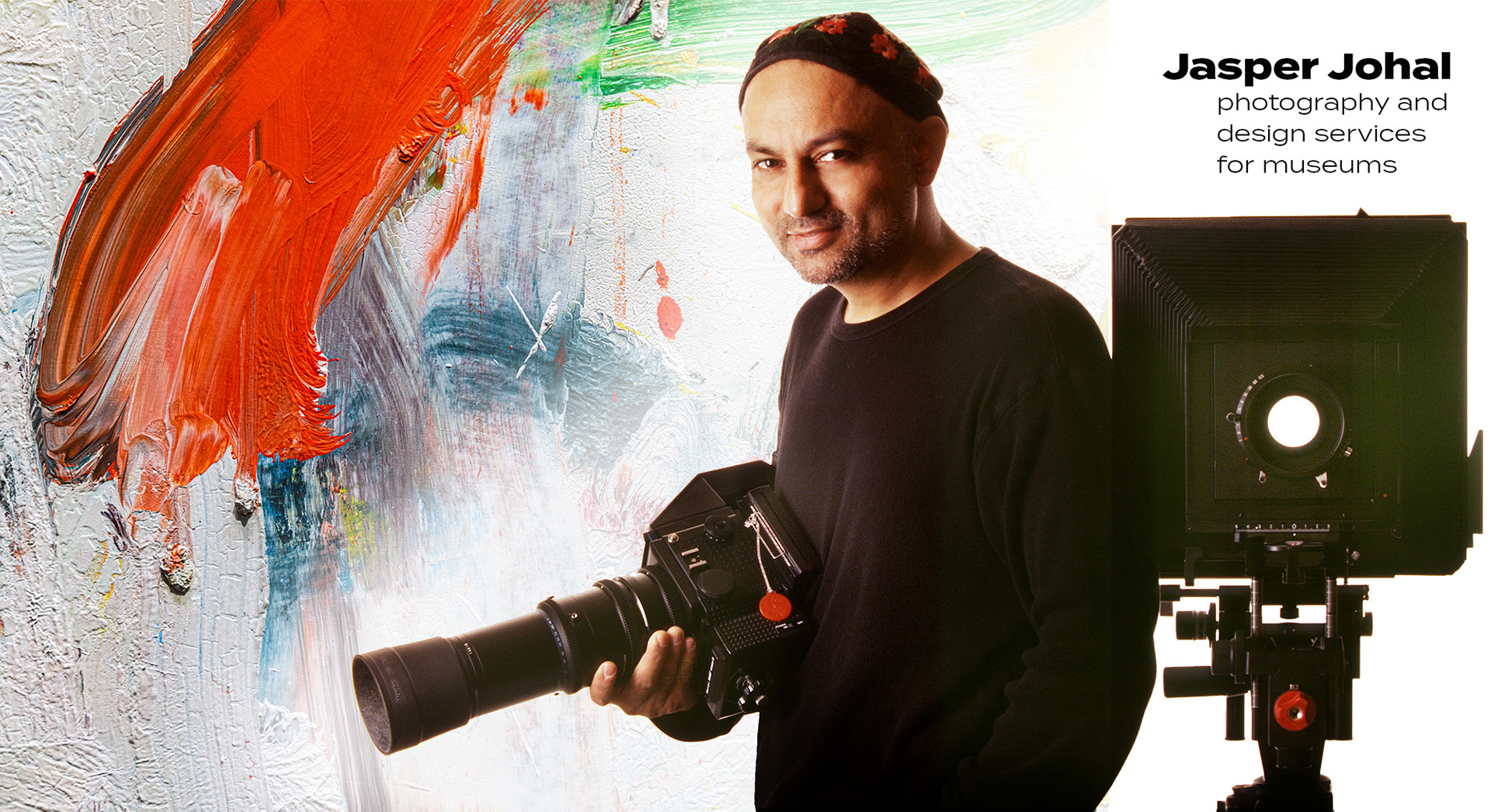 Photo of Jasper Johal with two large format cameras and detail of Willem de Kooning painting in back