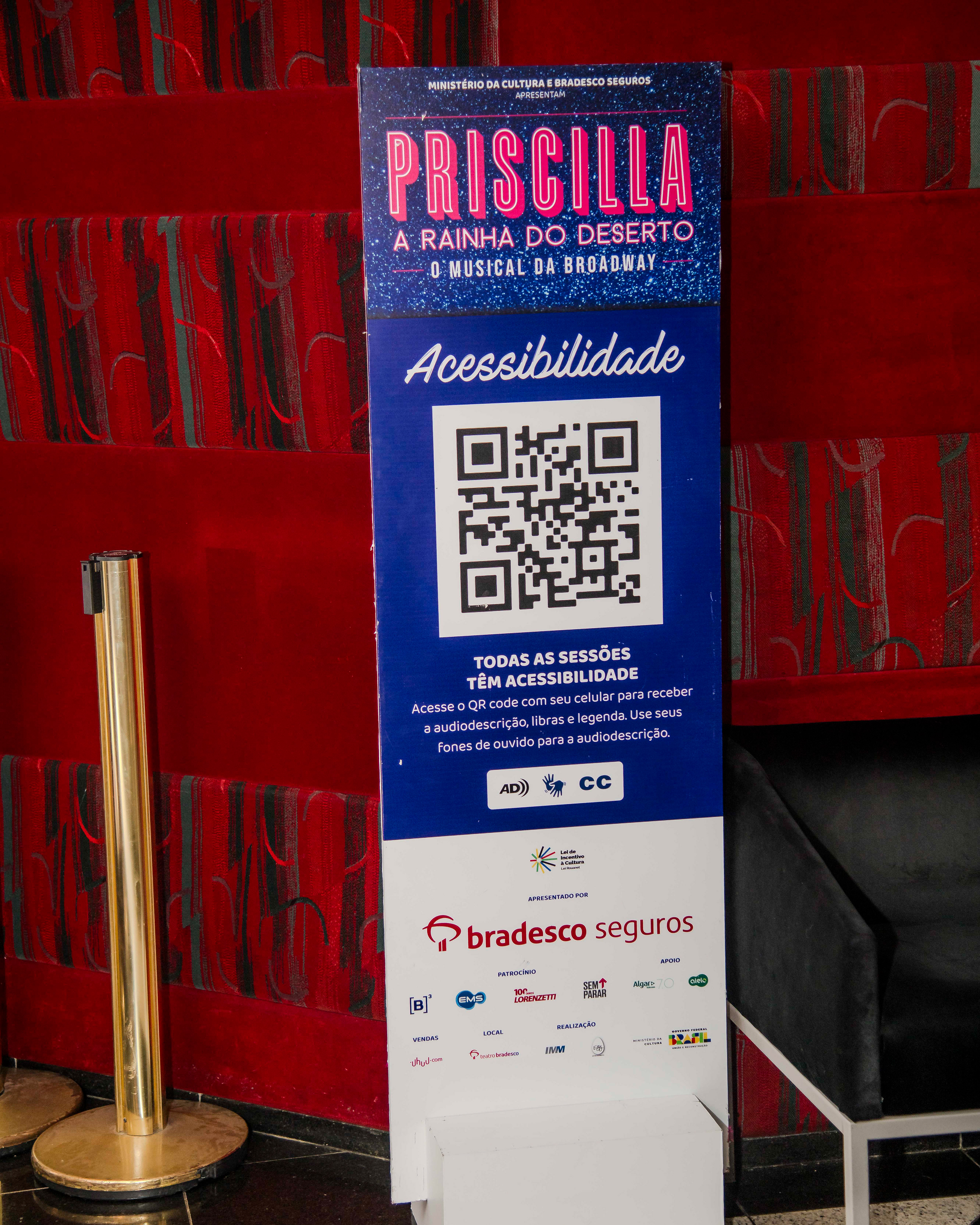 Totem with accessiblity information inside the Bradesco Theater foyer.