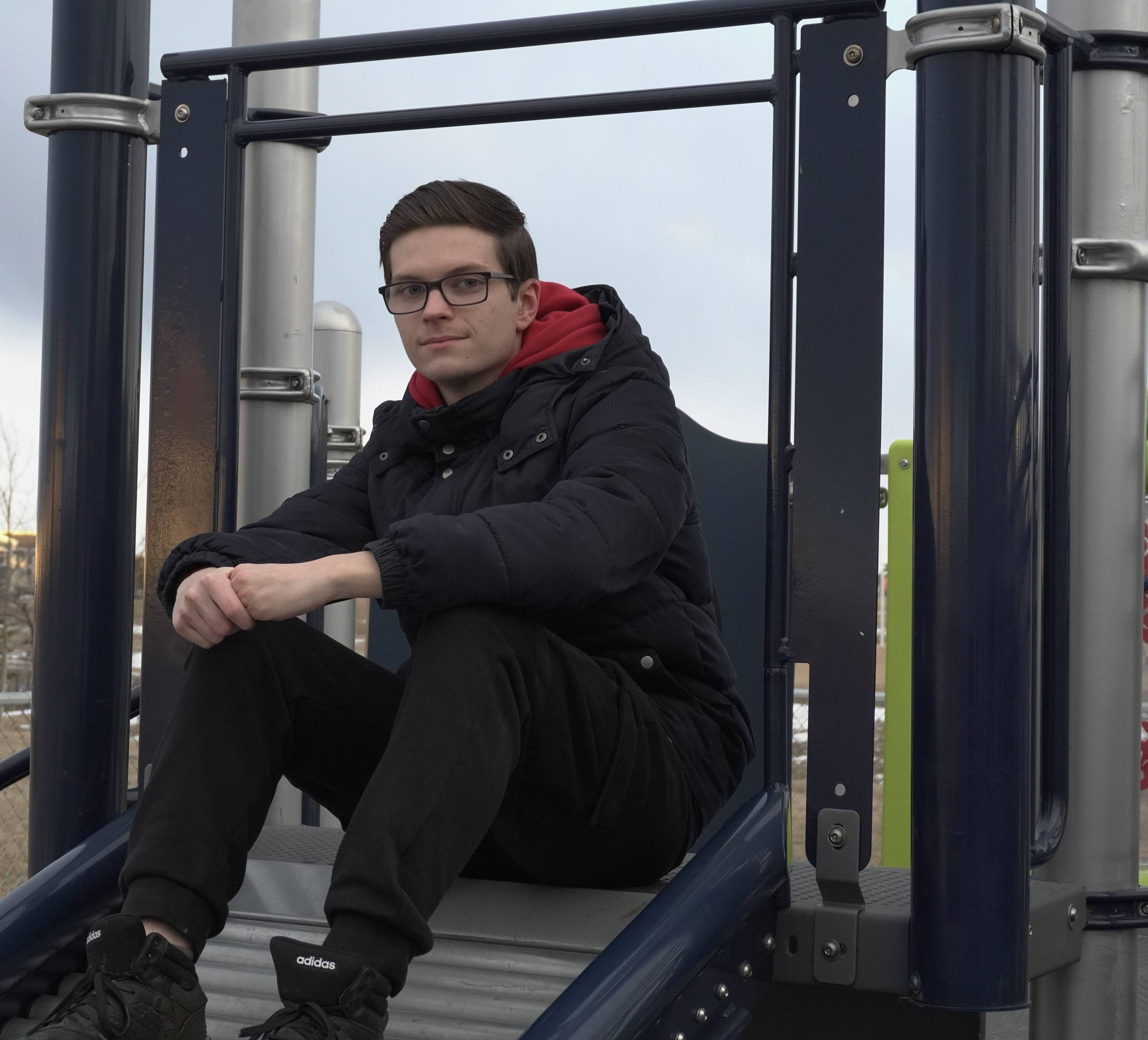 Ilya Stepanov sits atop a slide in a playground in the northwest of Calgary.