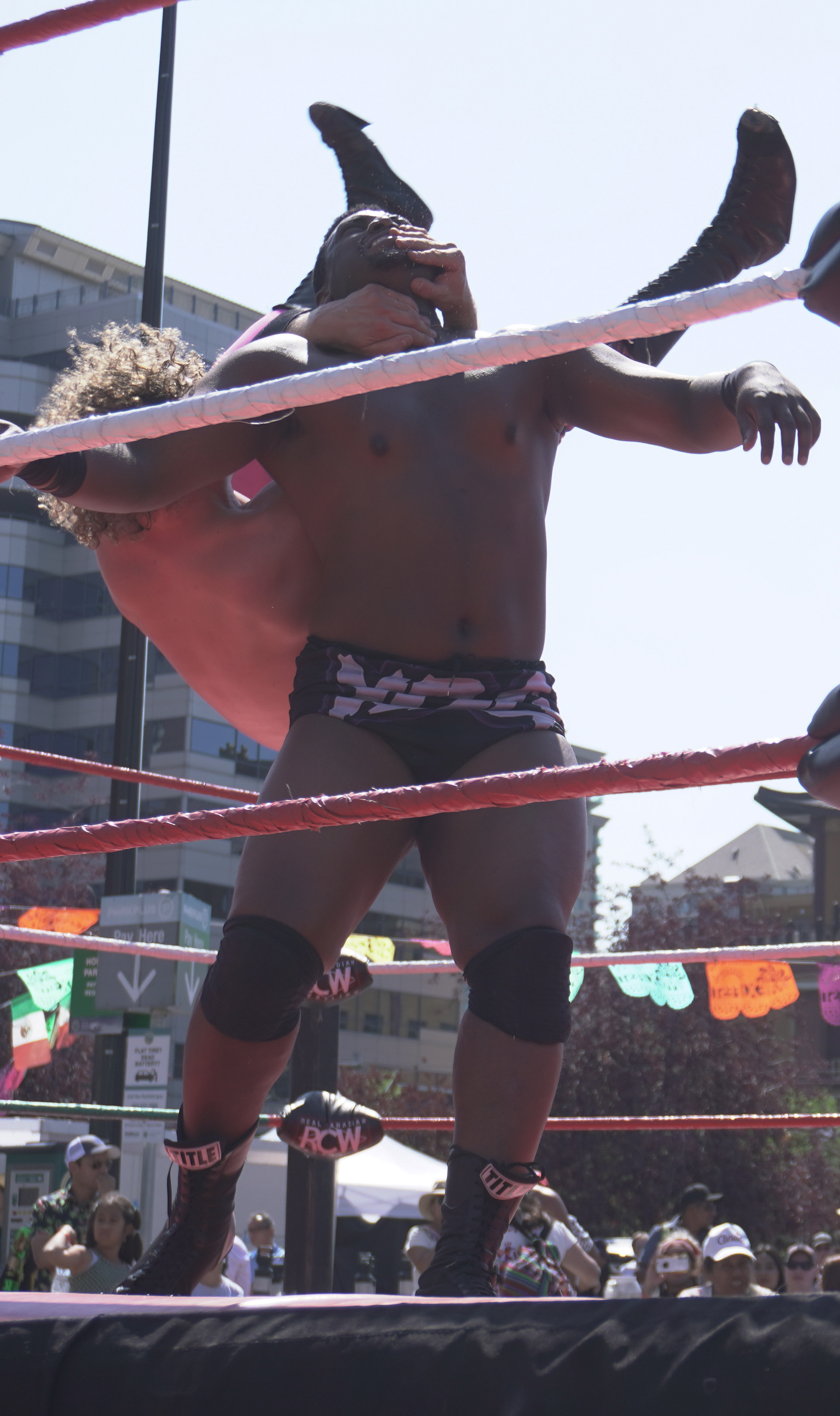 Bobby Schink (pink pants) grips the neck of Malik Melo (black shorts) for a takedown during their wrestling match on Saturday, July 8, 2023. This match was during Mexifest in downtown Calgary.