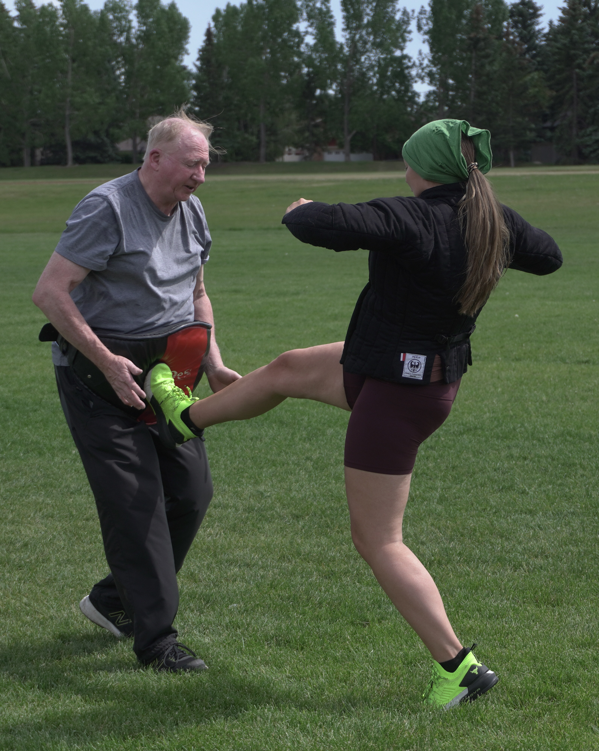 David Lawless (left), wearing a Muay Thai belly pad, takes a kick from Alexa Lacroix (right) outside of Midnapore School