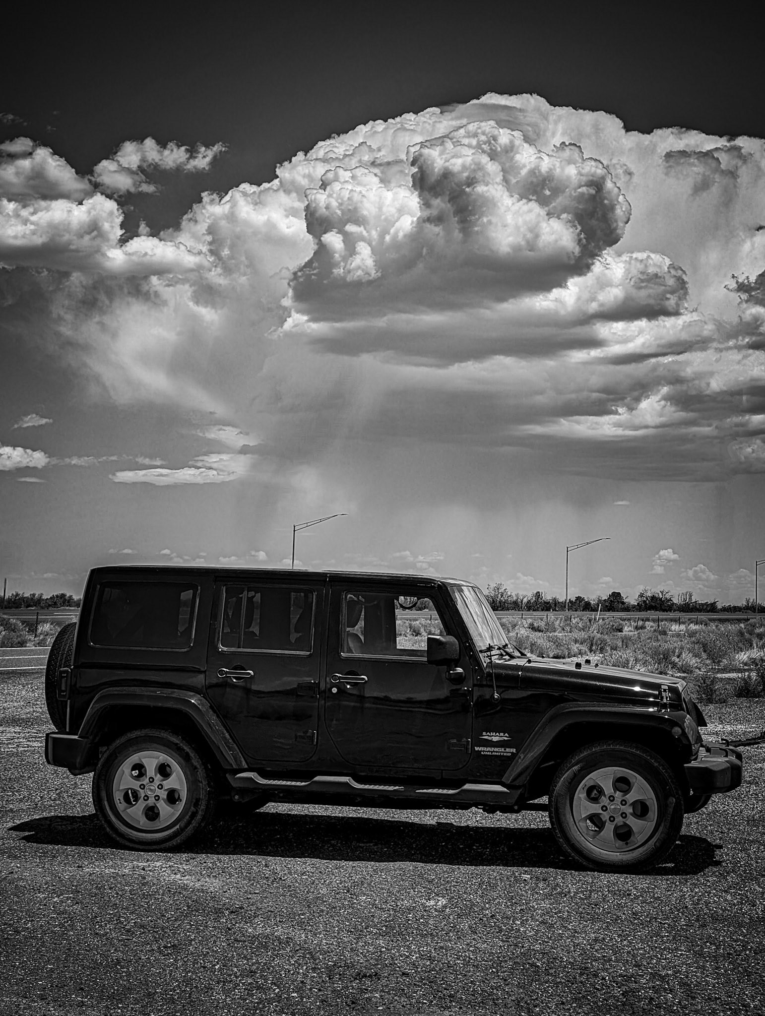 B&amp;W Jeep with developing thunderstorm