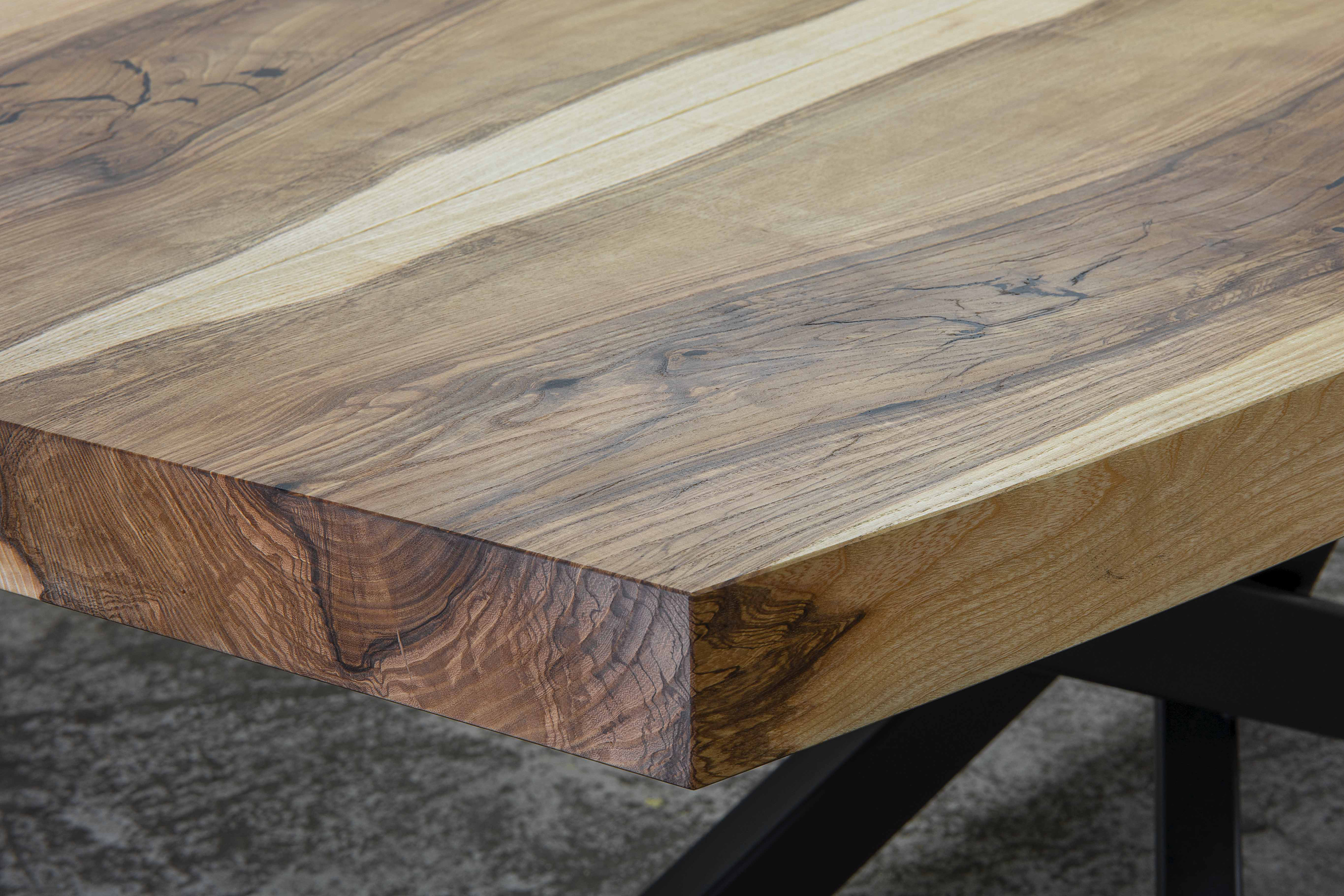 Detail of oval ash dining table top with pronounced wood grain