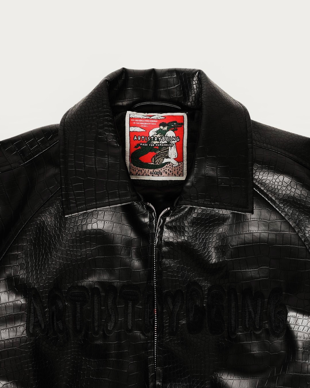 The croc-embossed vegan jacket showcases an original Artistrybeing® artwork as a woven neck tag.