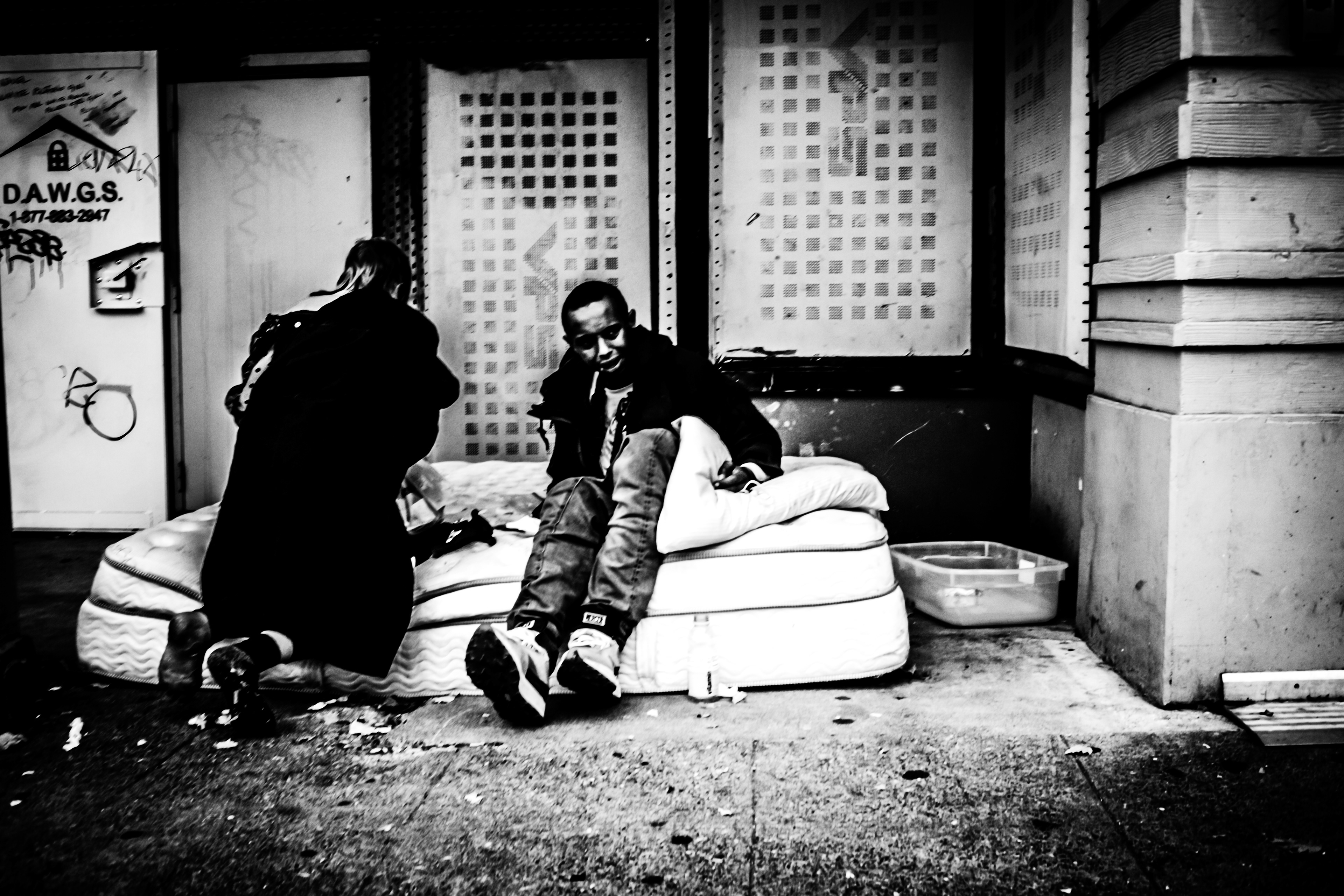 Two people on the matress at an easement in downtown Seattle