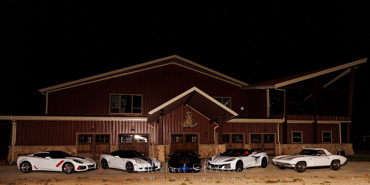 Photograph of 5 Corvettes at a hunting lodge. Photo was the setup image for an amazing light painting of all five cars and the lodge. Included in the photo are a 1966 Corvette Stingray Convertible, a 2004 Corvette C6 Z06 Leman’s Commemorative Edition, a 2013 Corvette 60th Anniversary ZR1, a 2019 Corvette ZR1, and a 2023 Corvette Z06!
