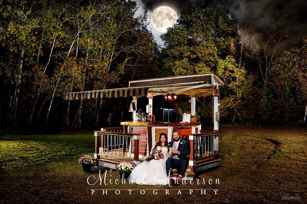 A fun light painted wedding photo of the cute couple at the bar that the bride's dad built for their backyard wedding.