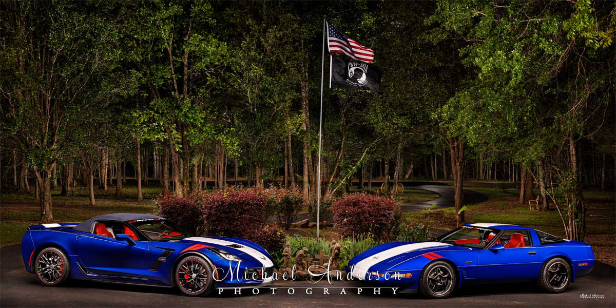 A pretty light painted photograph of a pair of Red, White, and Admiral Blue Corvettes. A 2019 Corvette Grand Sport on the left, and a 1996 Corvette Grand Sport on the right.