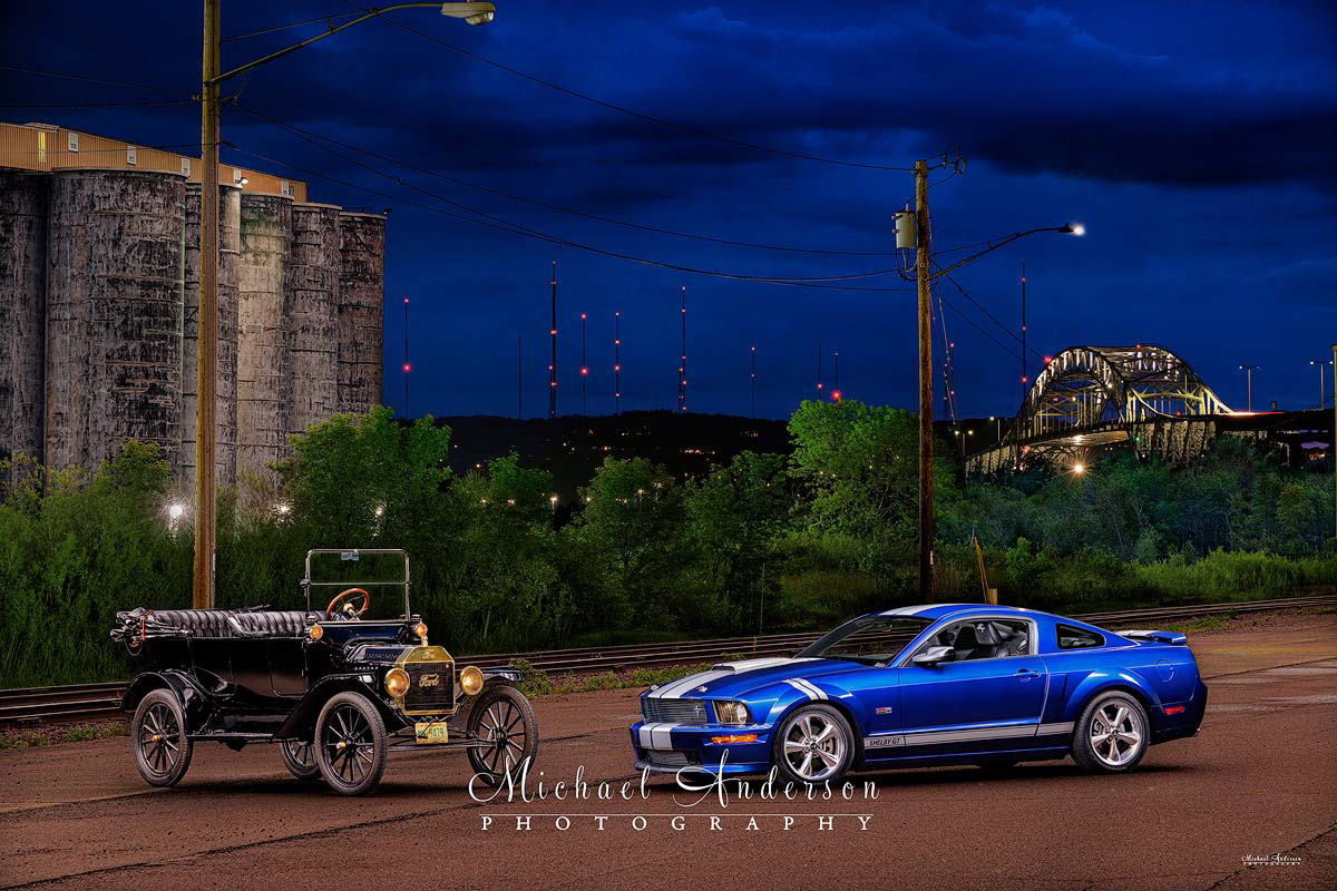 A pretty light painted photograph of a 1915 Ford Model T and a 2008 Ford Shelby Mustang.