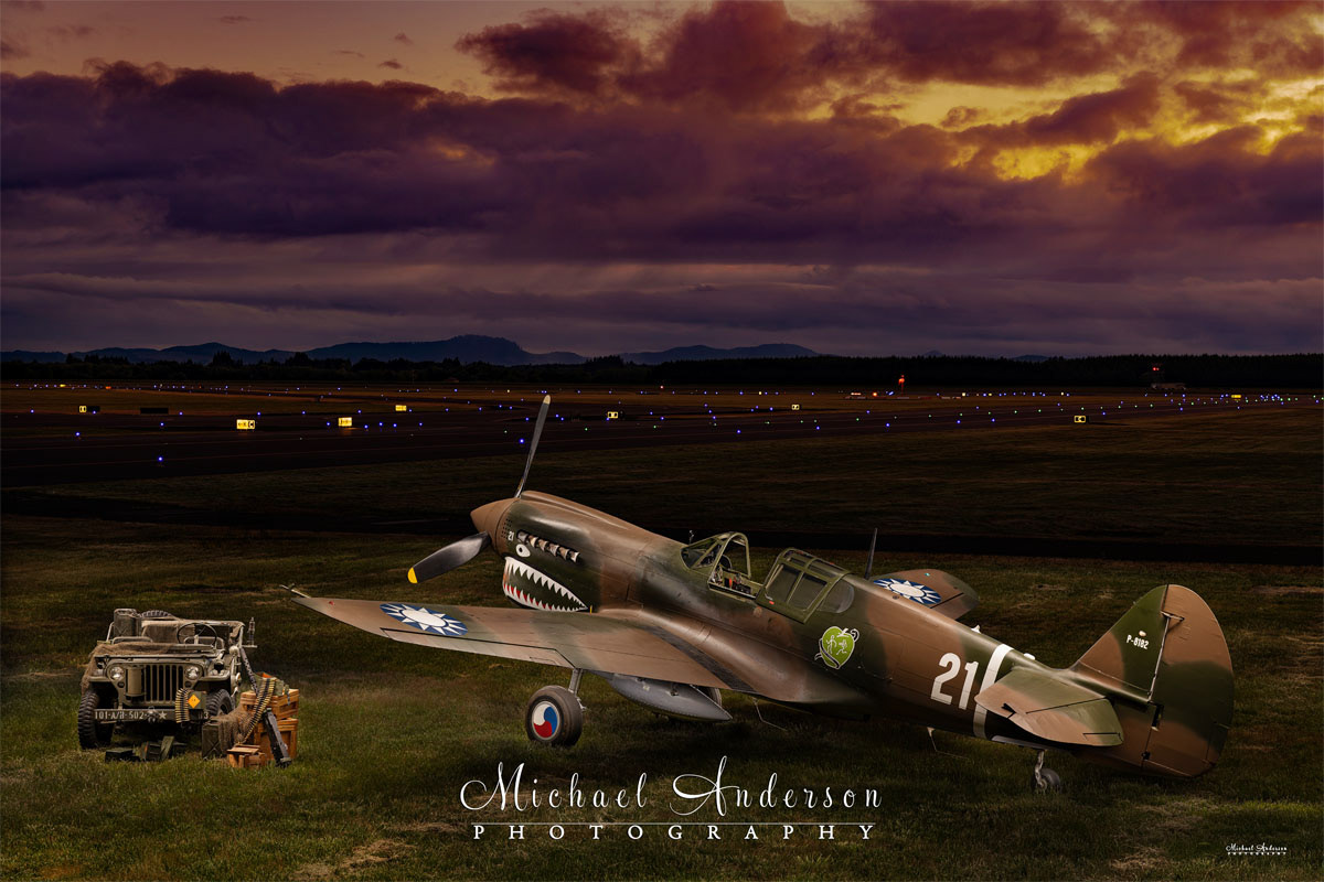 A wonderful light painted photograph of a 1943 P-40 N-1 Kittyhawk with a WWII Willys Jeep created at Soaring By The Sea Foundation in Eugene, Oregon.