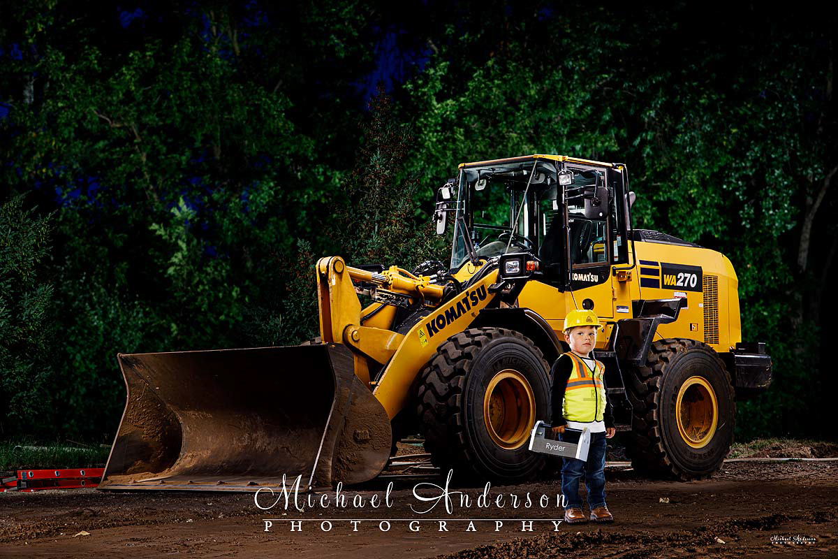 A cool light painted photo of a little boy and a Komatsu WA270 8 front loader. The boy was added in post-production using green screen technology.