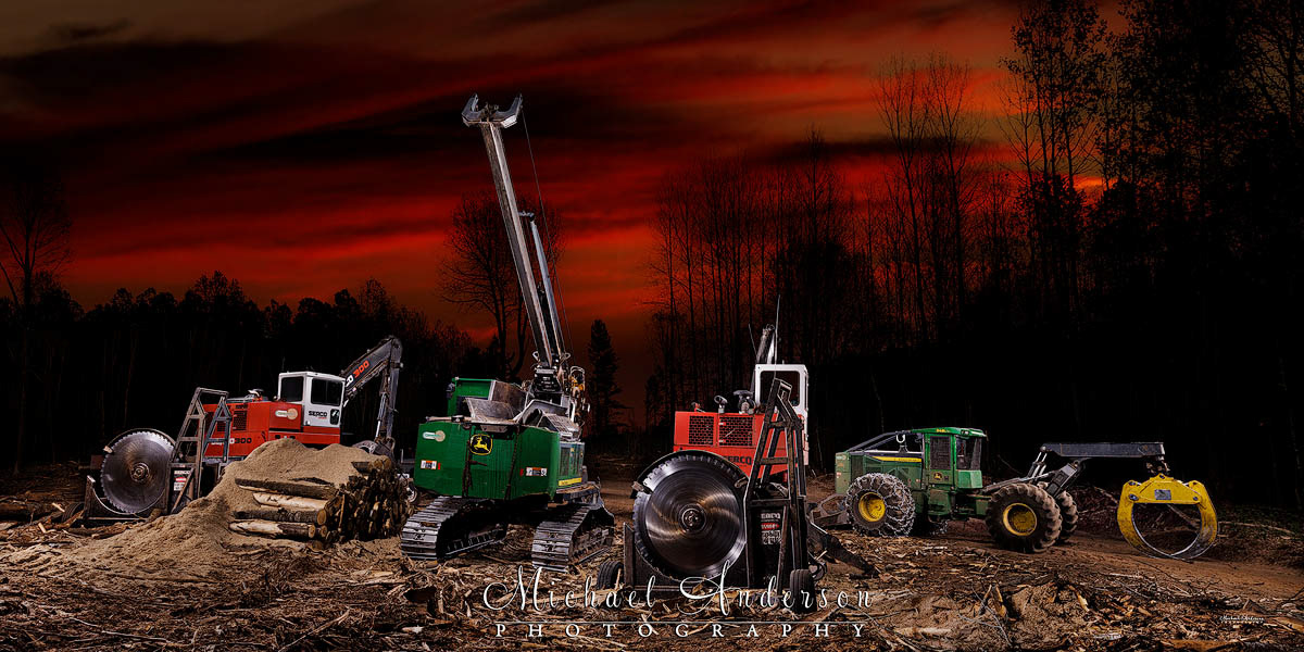 A cool light painted photograph of a SERCO 300 Series Loader with a 72″ SERCO Saw, a John Deere 2154G Swing Machine with a Pro Pac Delimber, and a second SERCO 300 Series Loader with a 72″ SERCO Saw. And, on the far right, a John Deere 948L-II Grapple Skidder.