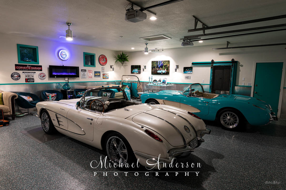 Photo of a pair of C1 Corvette Convertibles, a 1957 and a 1958, in a She Shed.