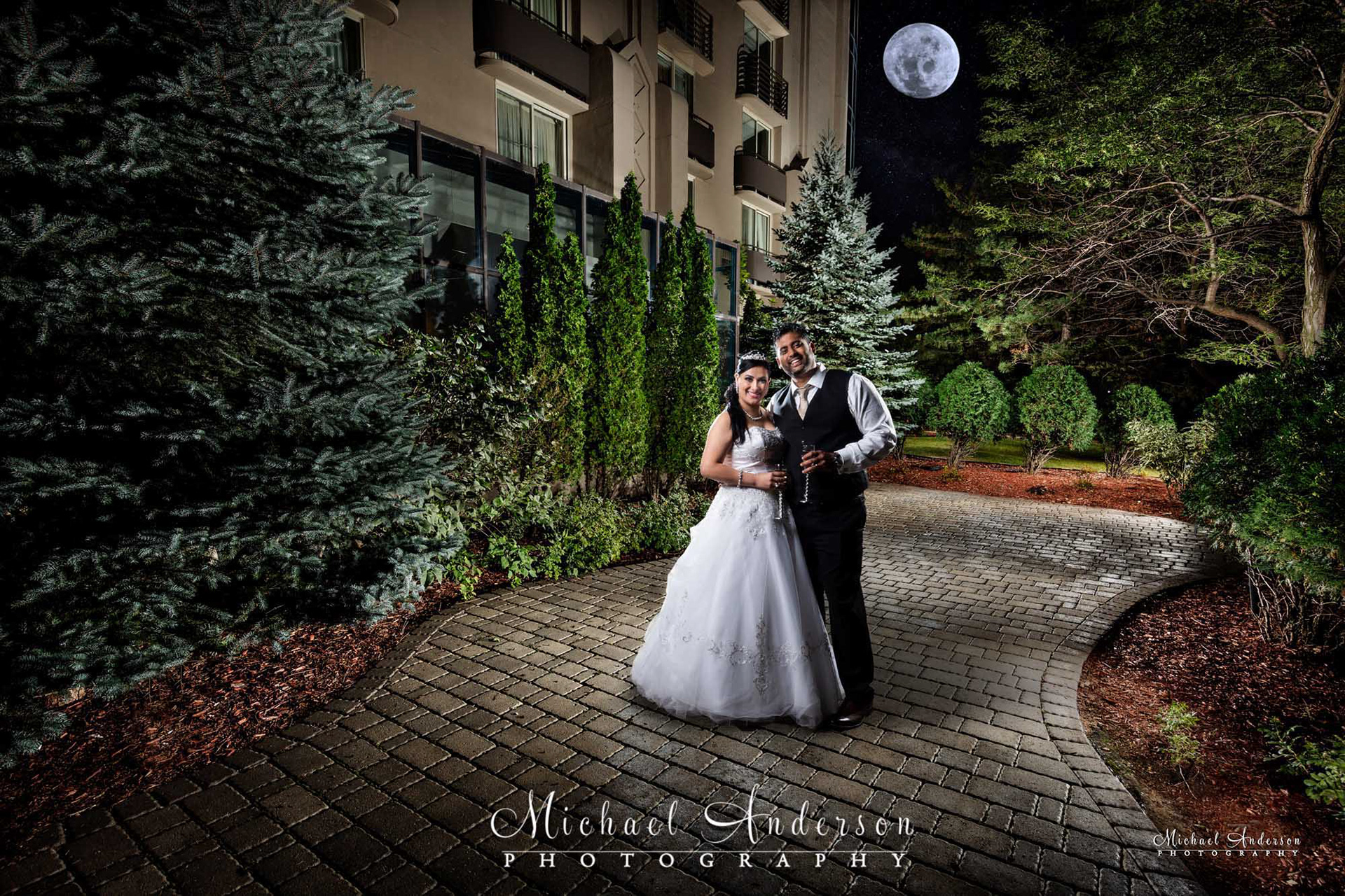 A pretty light painted wedding photograph, created under a full moon, in the outdoor courtyard at the Embassy Suites Airport in Bloomington, MN.