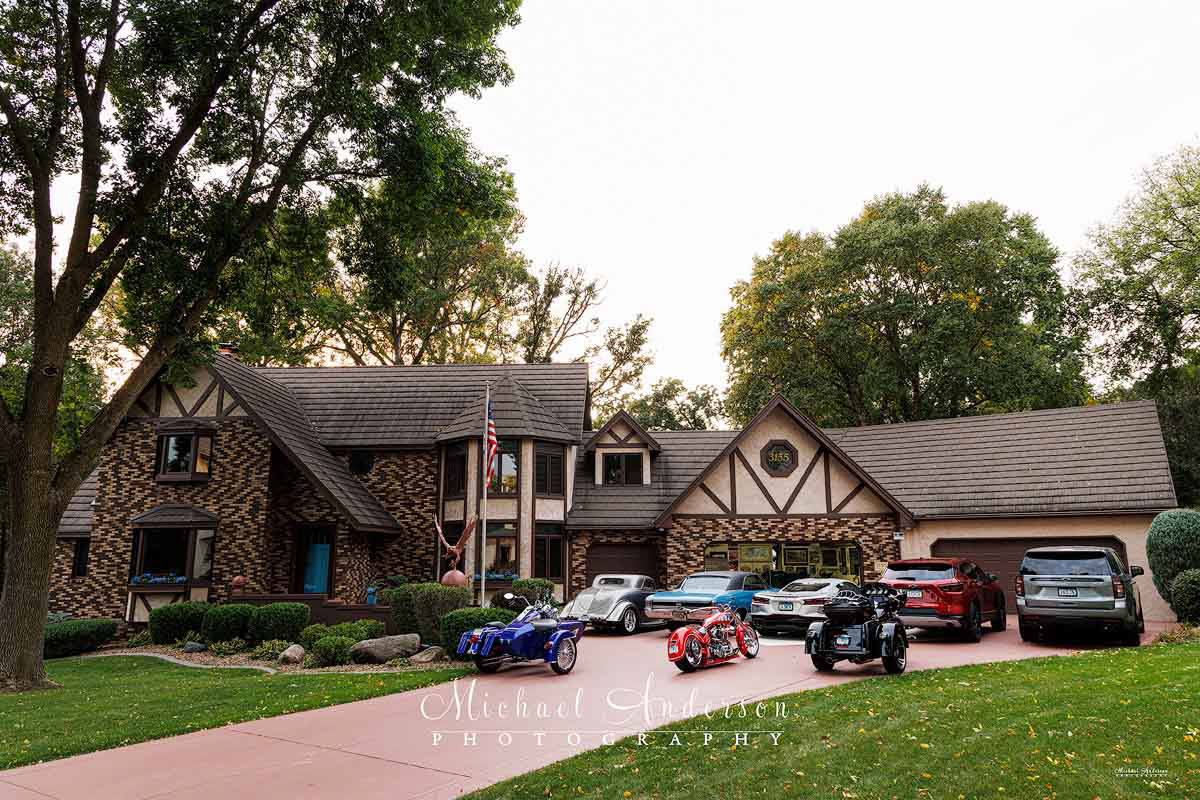 A pre-light painting set up photo that includes 8 vehicles as well as the client's beautiful home! The 3 Motorcycles are a 1995 Custom Harley-Davidson Road King, a Custom 2005 Speedway Chopper, a 2022 CVO Harley-Davidson. The other 5 Vehicles are a ’34 Ford 3-Window Coupe, a Marina Blue 1967 Chevelle, a 2023 Z3 Corvette Stingray Coupe 3LT, a 2024 Chevy Blazer AWD, and a 2023 Chevy Tahoe 4WD RST.