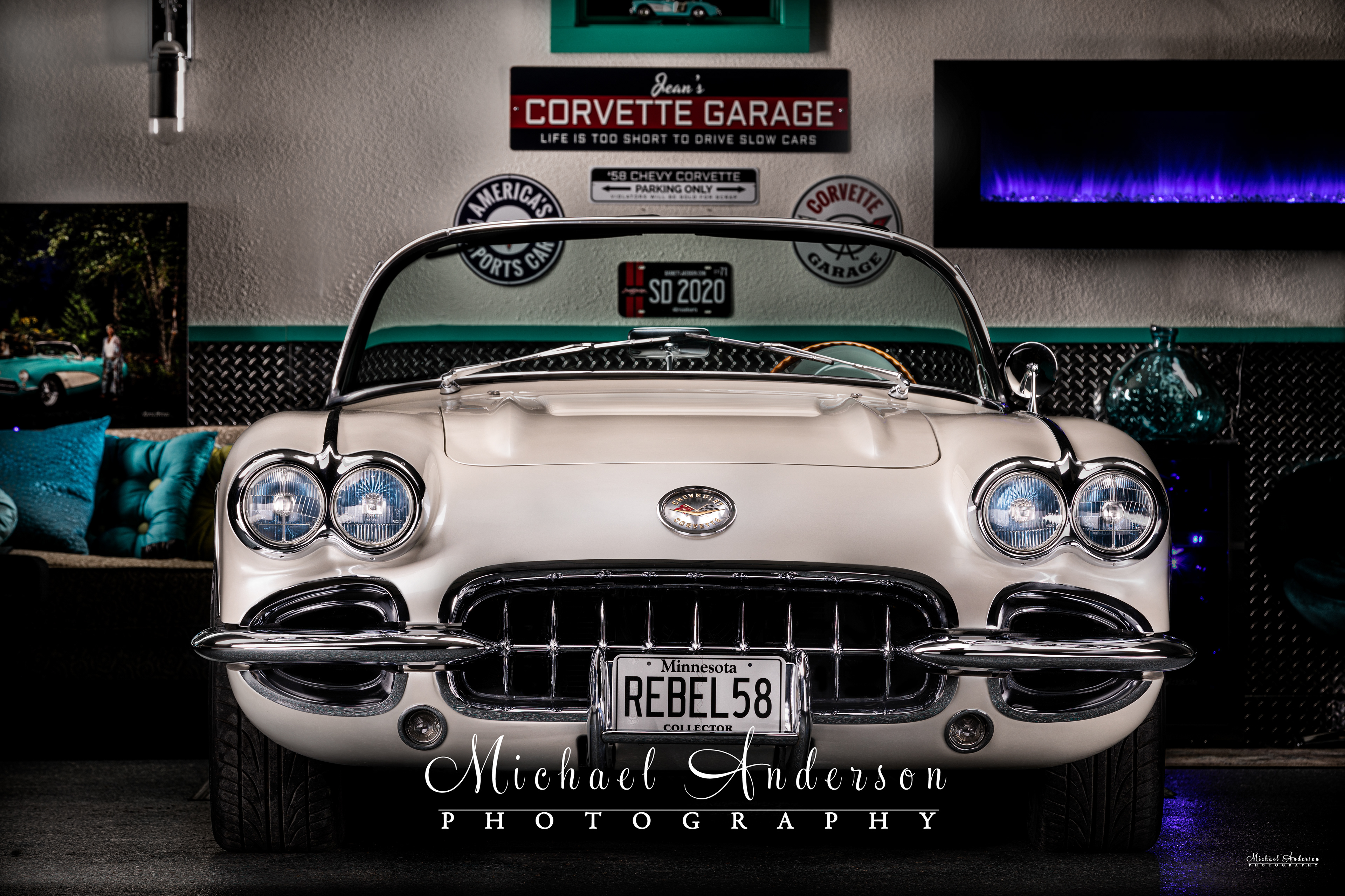 Light painted photo of the front end of a 1958 C1 Corvette in the owner's matching garage.