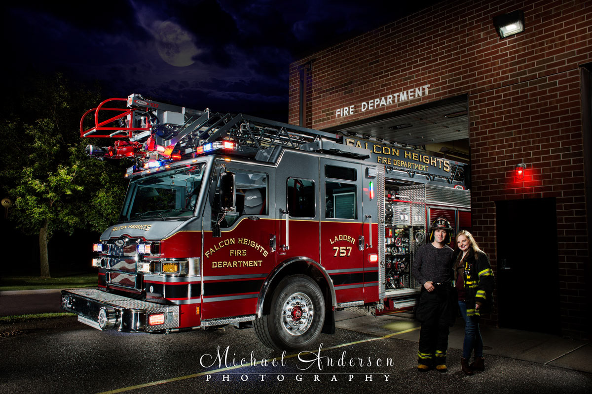 A cool light painted engagement photo of Falcon Heights Fire Department Ladder 757 with a firefighter and his fiancée.