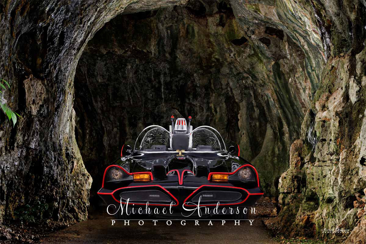 A cool light-painted photo of the Batmobile in the entrance to the Batcave.