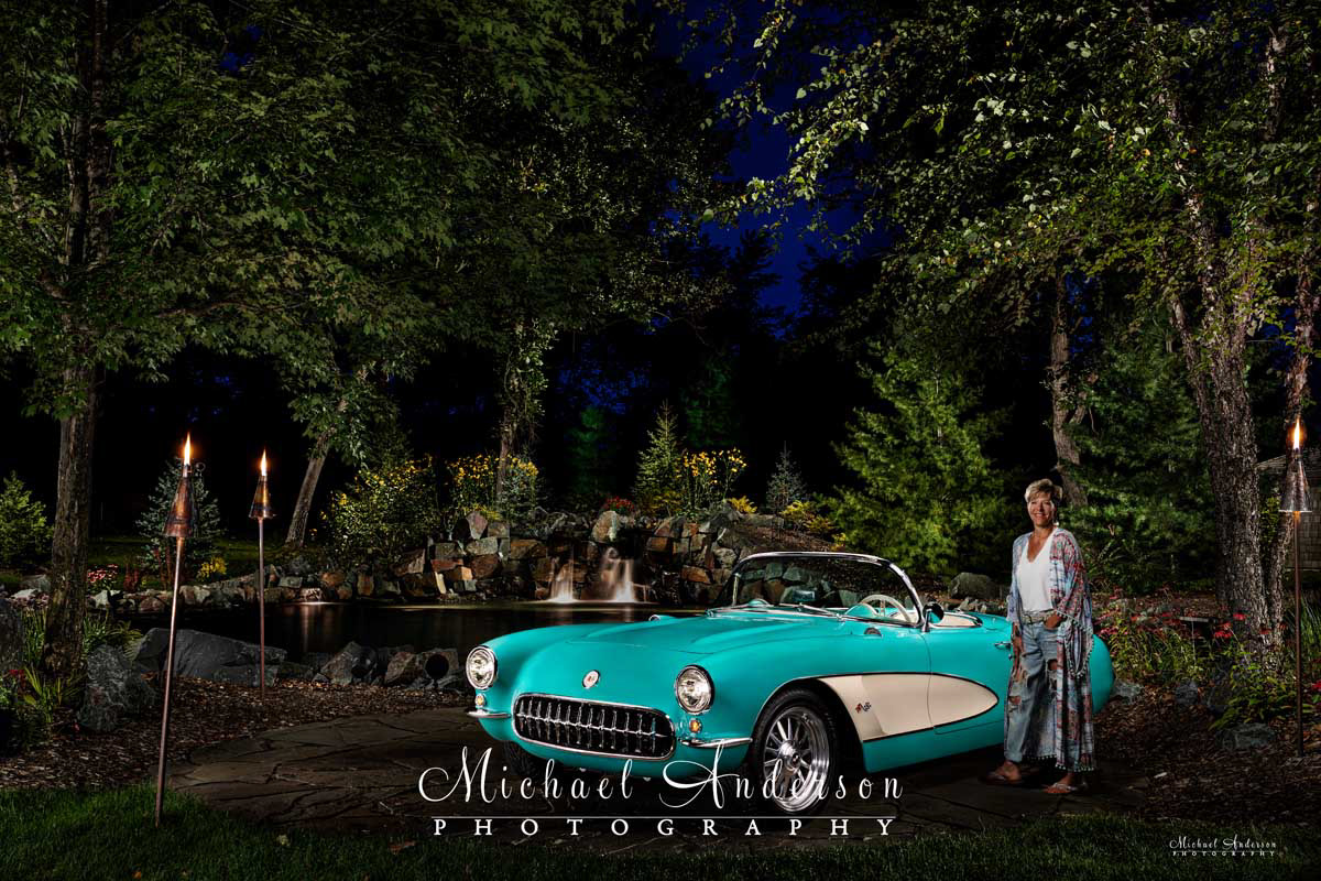 A beautiful light painted photograph of the owner and her 1957 C1 Corvette Convertible. The car’s colors are Cascade Green with beige.