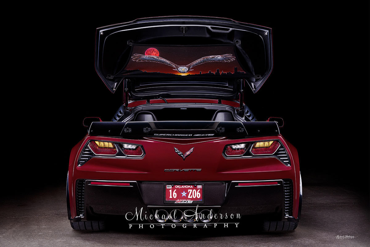 A cool light-painted photograph of the rear end of a beautiful Long Beach Red 2016 C7 Corvette Z06. A custom hand-painted image of a soaring bald eagle and a blood moon made the image even better!