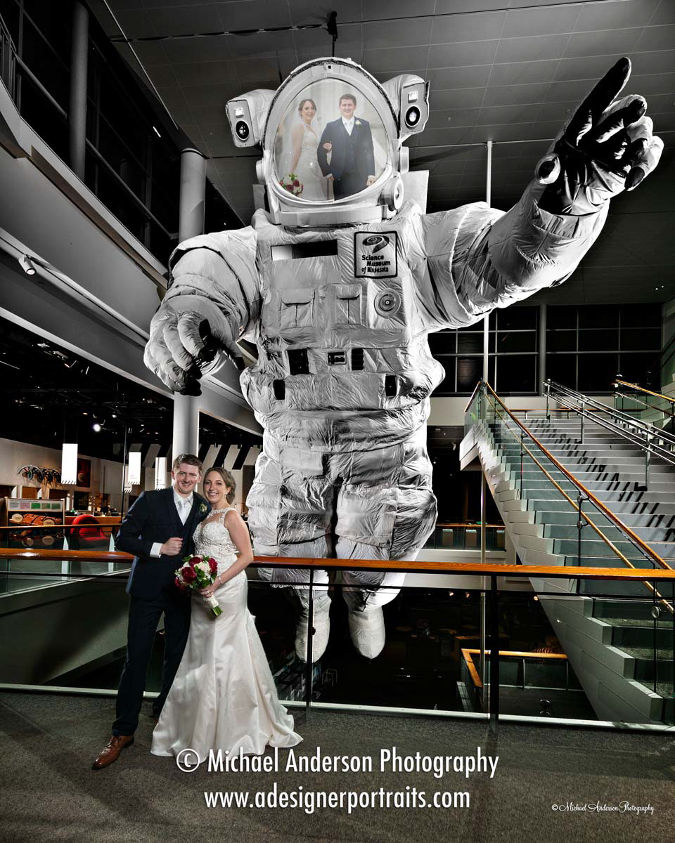 A cool light painted wedding photo of the bride and groom by the huge astronaut at their wedding reception at the Science Museum of Minnesota.