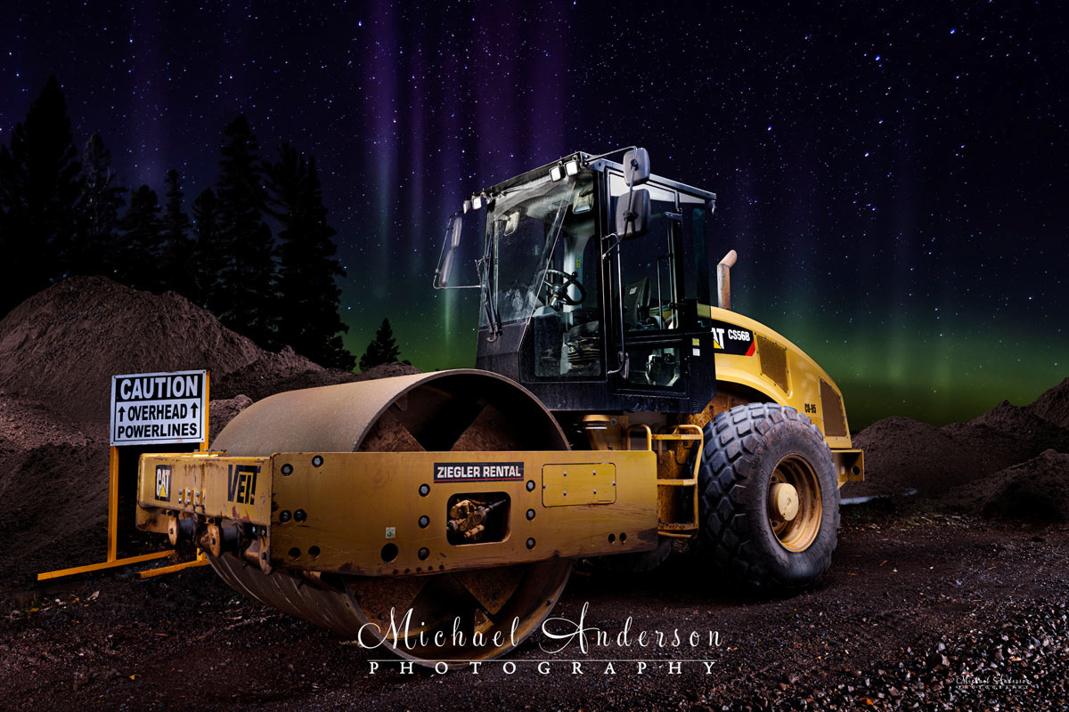 A cool light painted photograph of a VEIT Caterpillar CS56B, photographed on the North Shore of Lake Superior, under the Aurora Borealis.