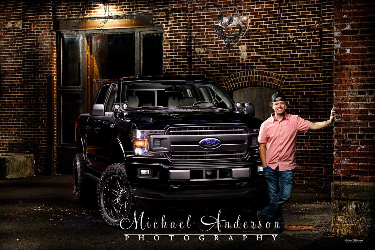 A cool light painted senior portrait of a boy with his Ford F-150 in downtown Stillwater, MN.