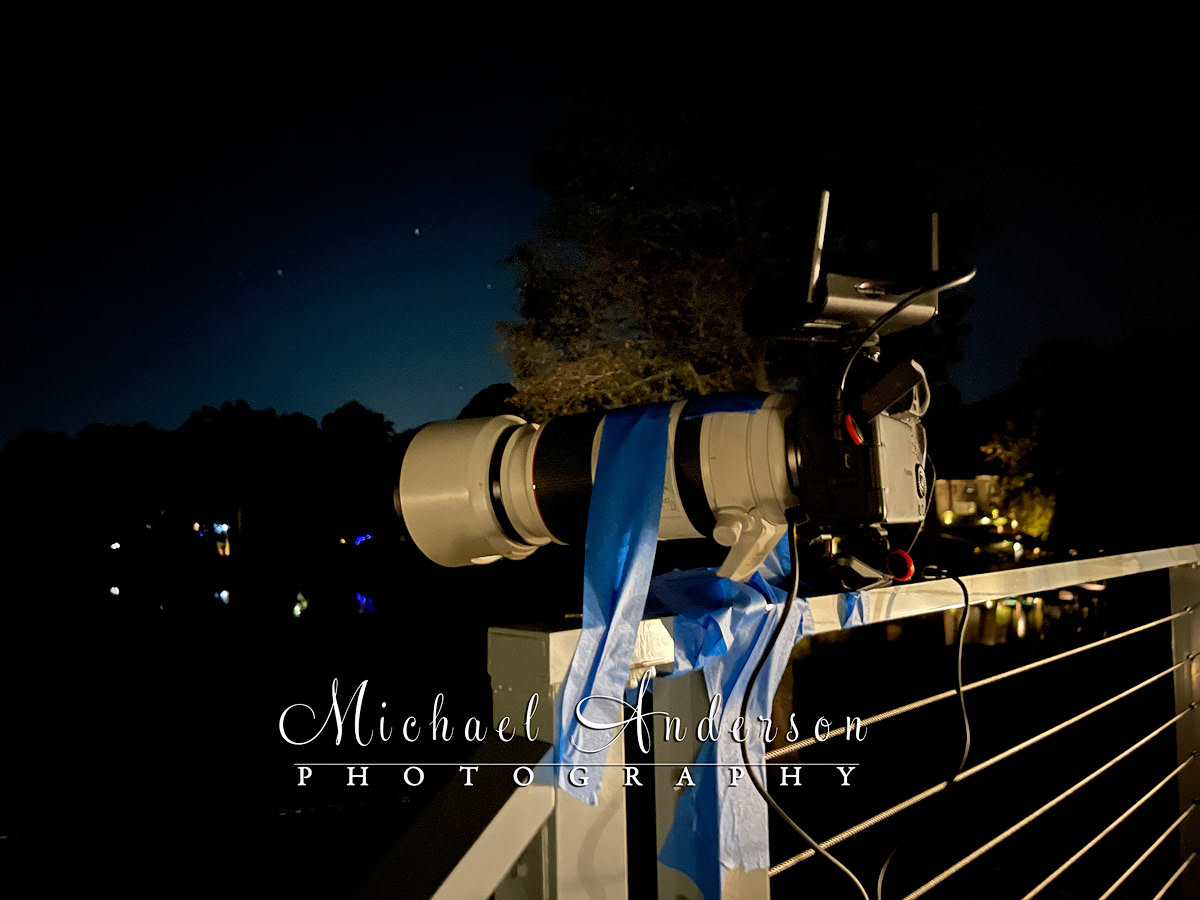 A mock tripod created "MacGyver Style" using a deck railing, and painter's tape, to hold everything in place.