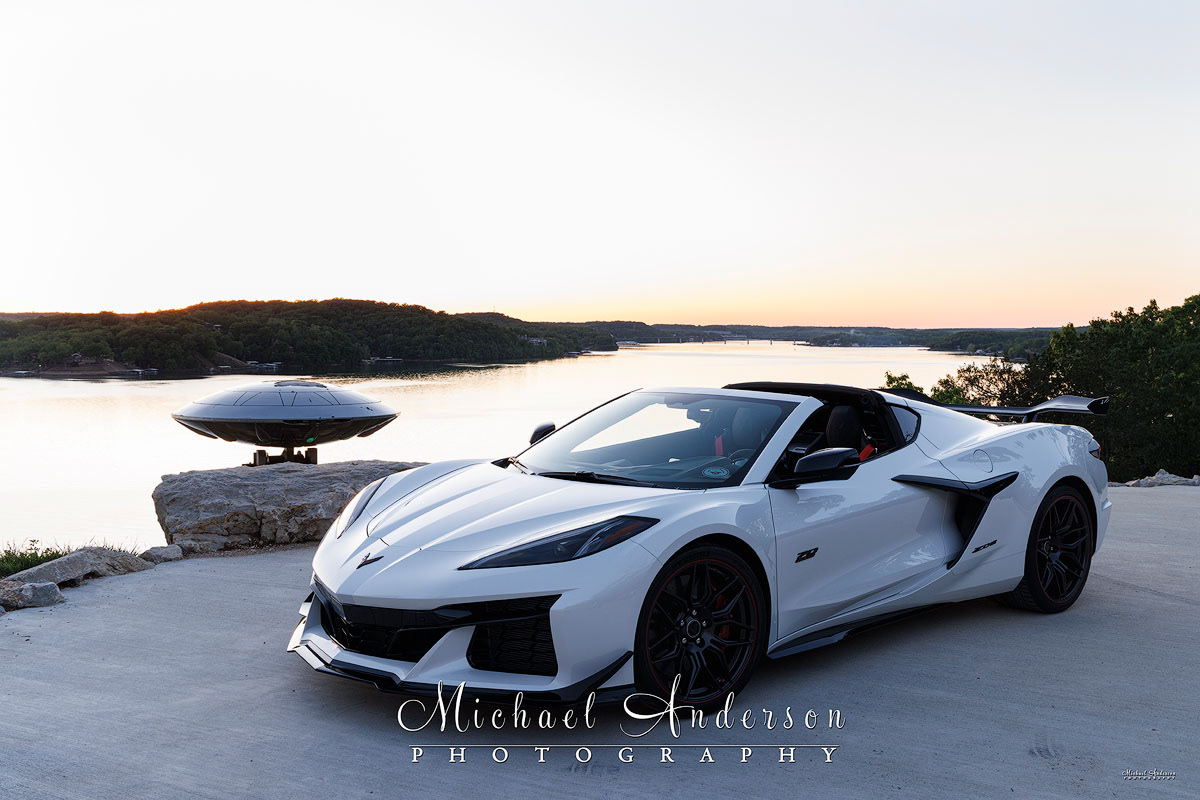 A pre-light painting photograph of a white 70th Anniversary Corvette Z06 and the flying saucer from the movie "Men In Black".