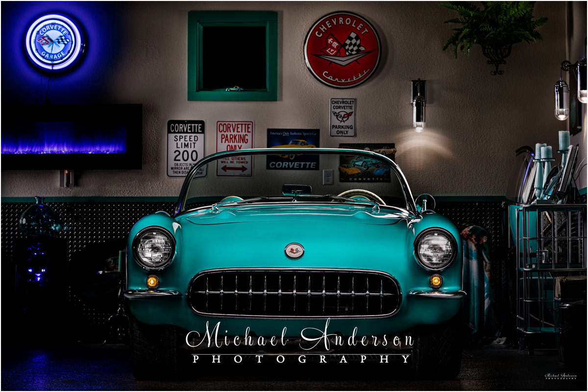 Light painted photo of the front end of a 1957 Corvette in the owner's matching garage.