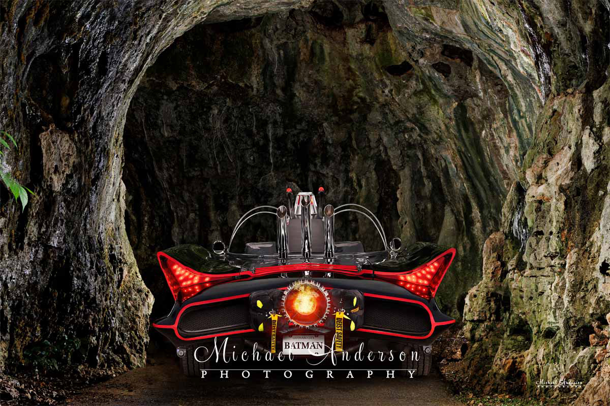 A cool light-painted photo of the Batmobile entering the Batcave.