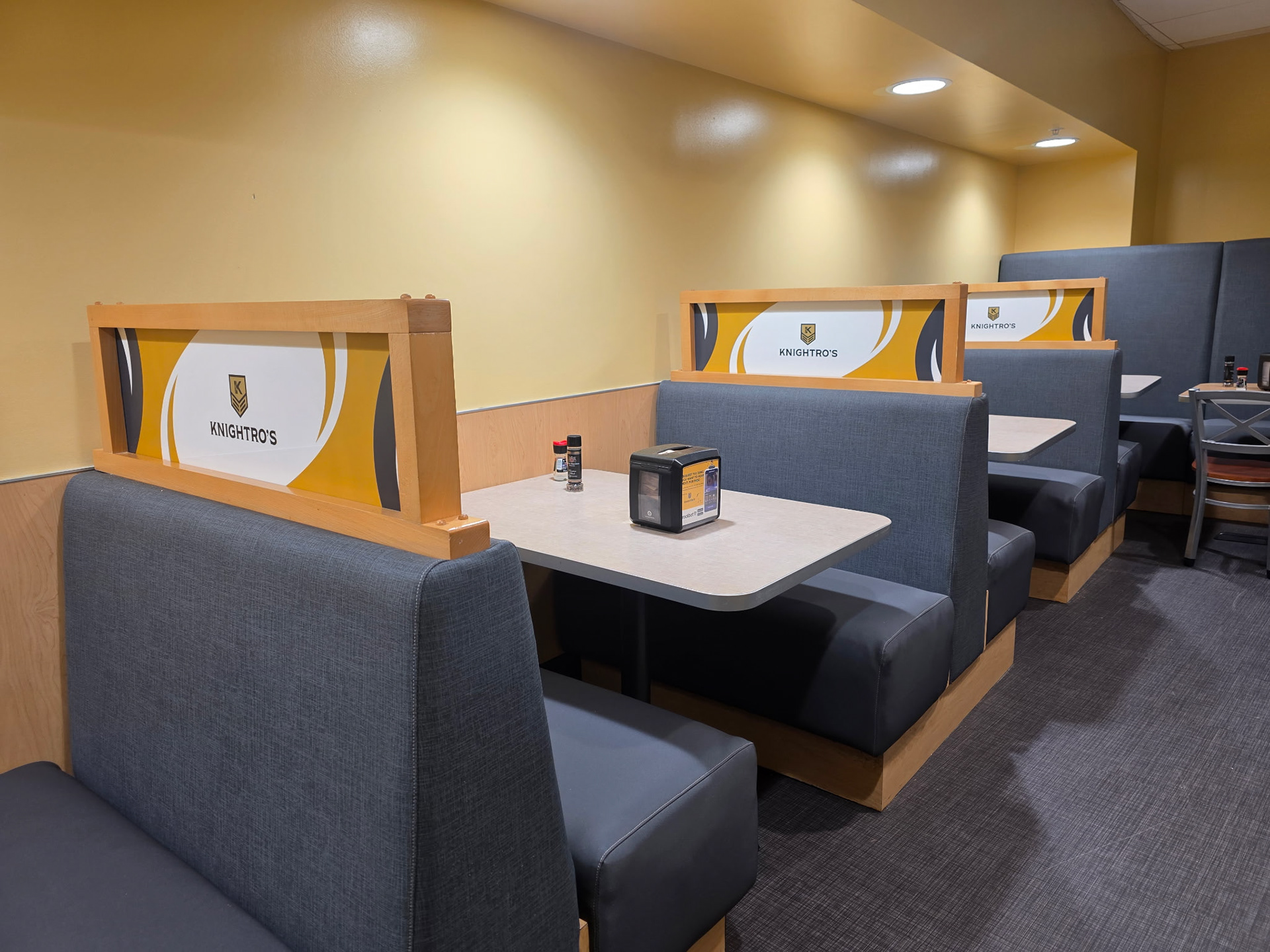 Project: Knightro's Dining Hall – Seating Environmental Graphics  To accompany the rebranding of Knightro's Dining Hall, I designed custom graphics for the booth seating dividers. The goal was to ensure the new visual identity extended beyond the signage and into the dining experience itself.