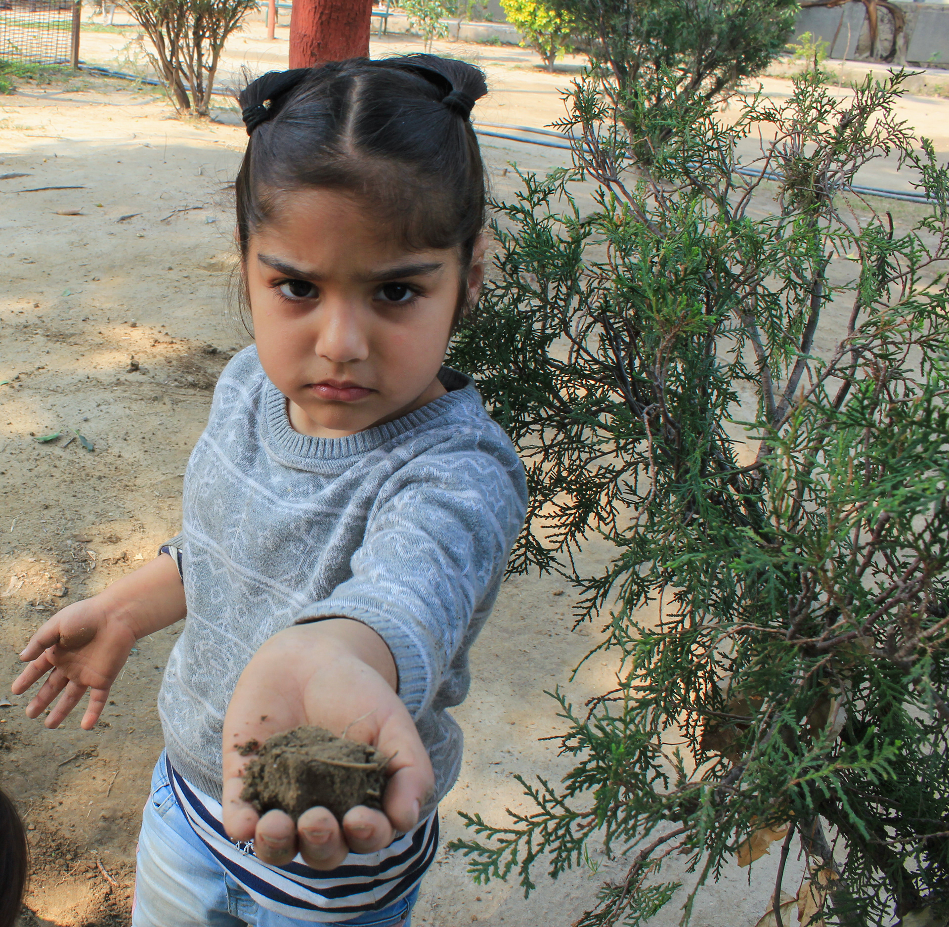 Inaayat offers a handful of mud to the photographer and wants to play. Occassionally you can find her playing with dirt and mud with her friends in the Madhuban park neighborhood in New Delhi, India.