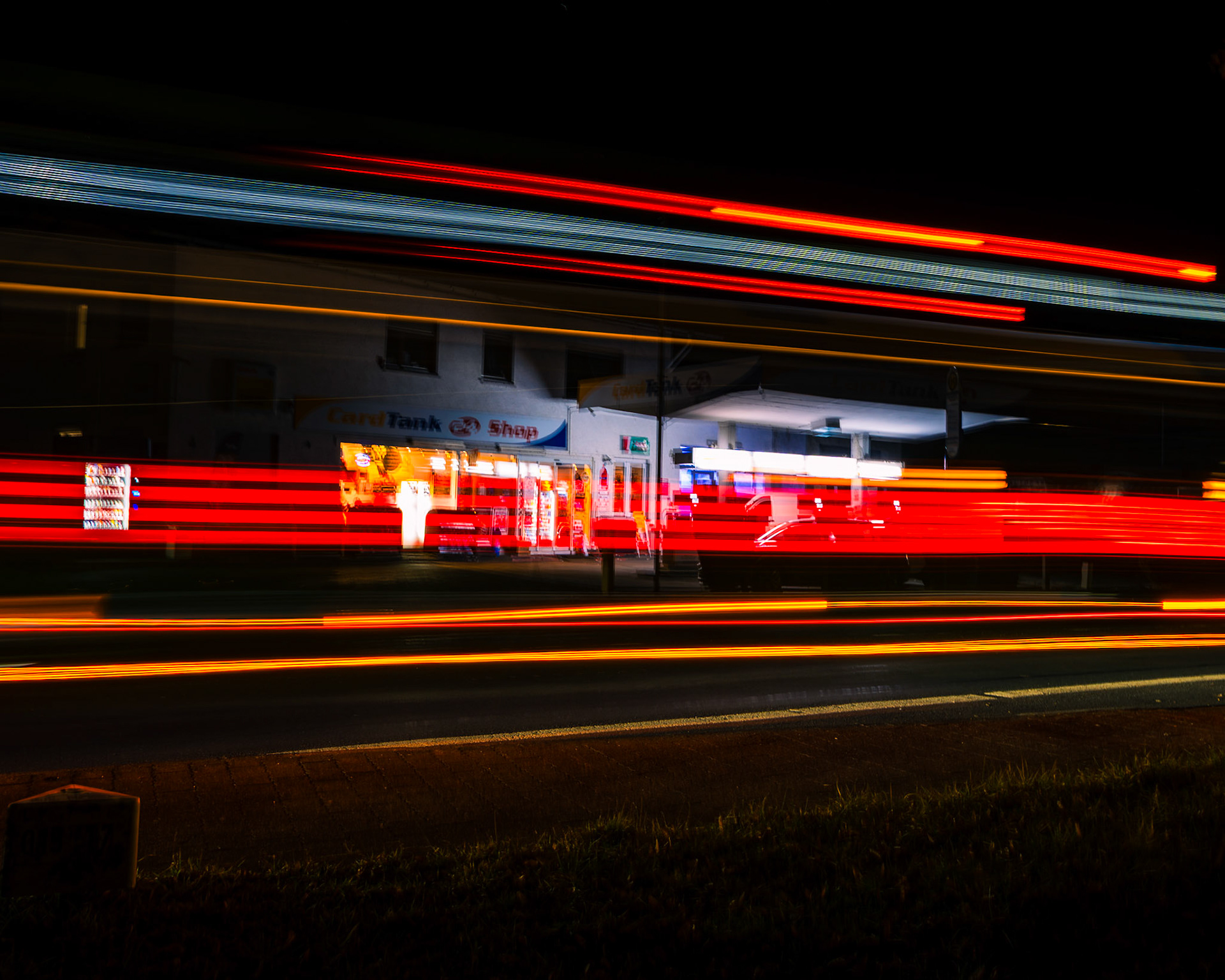 Bus-Lichtspur vor Tankstelle