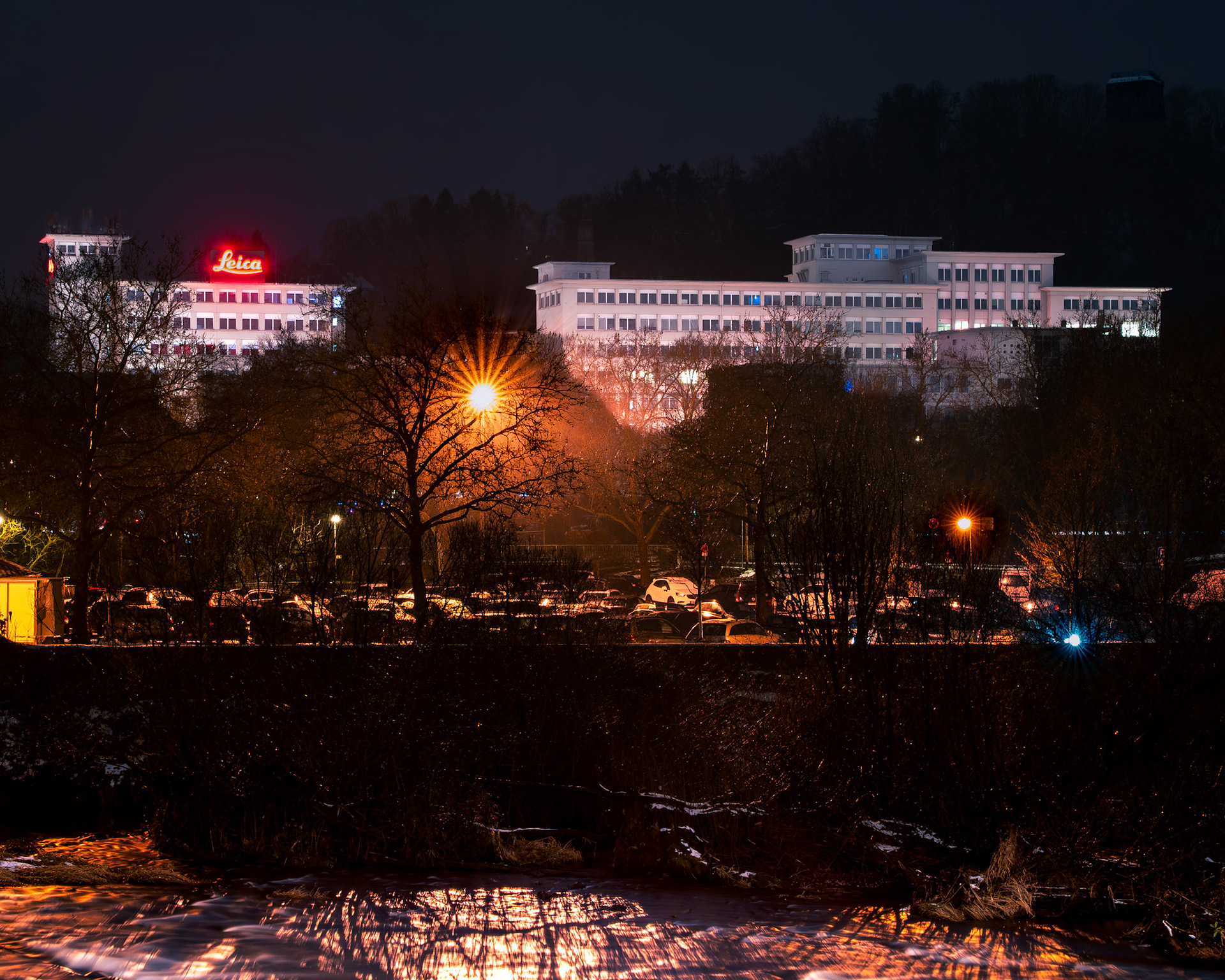 Altes Leitz-Gebäude bei Nacht mit beleuchteten Logos