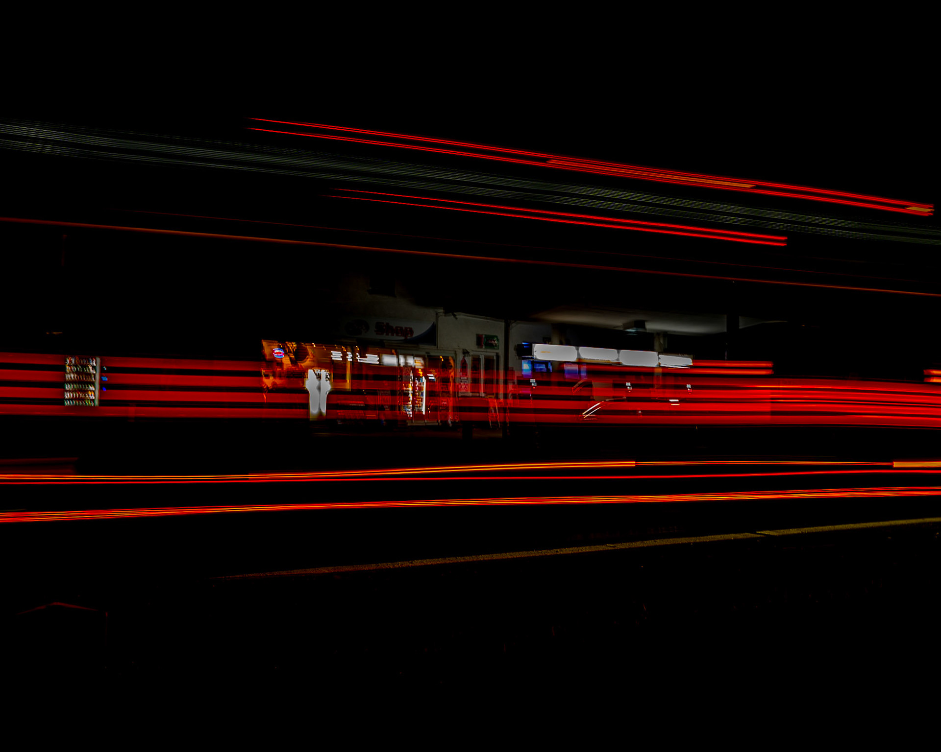 Bus-Lichtspur vor Tankstelle