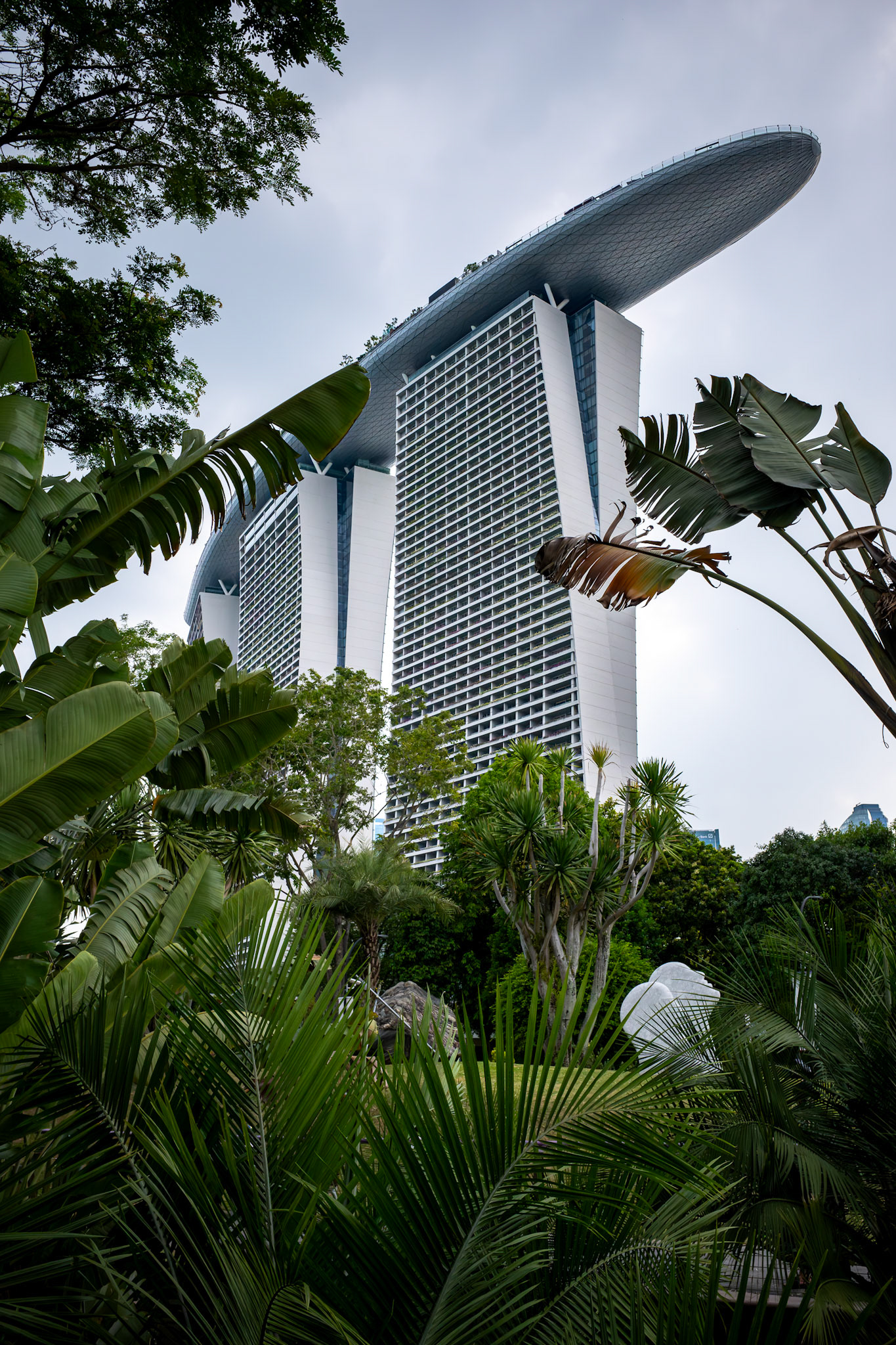 Außenansicht mit ikonischem Dach und tropischer Umgebung; das SkyPark-Deck verbindet die drei Türme.