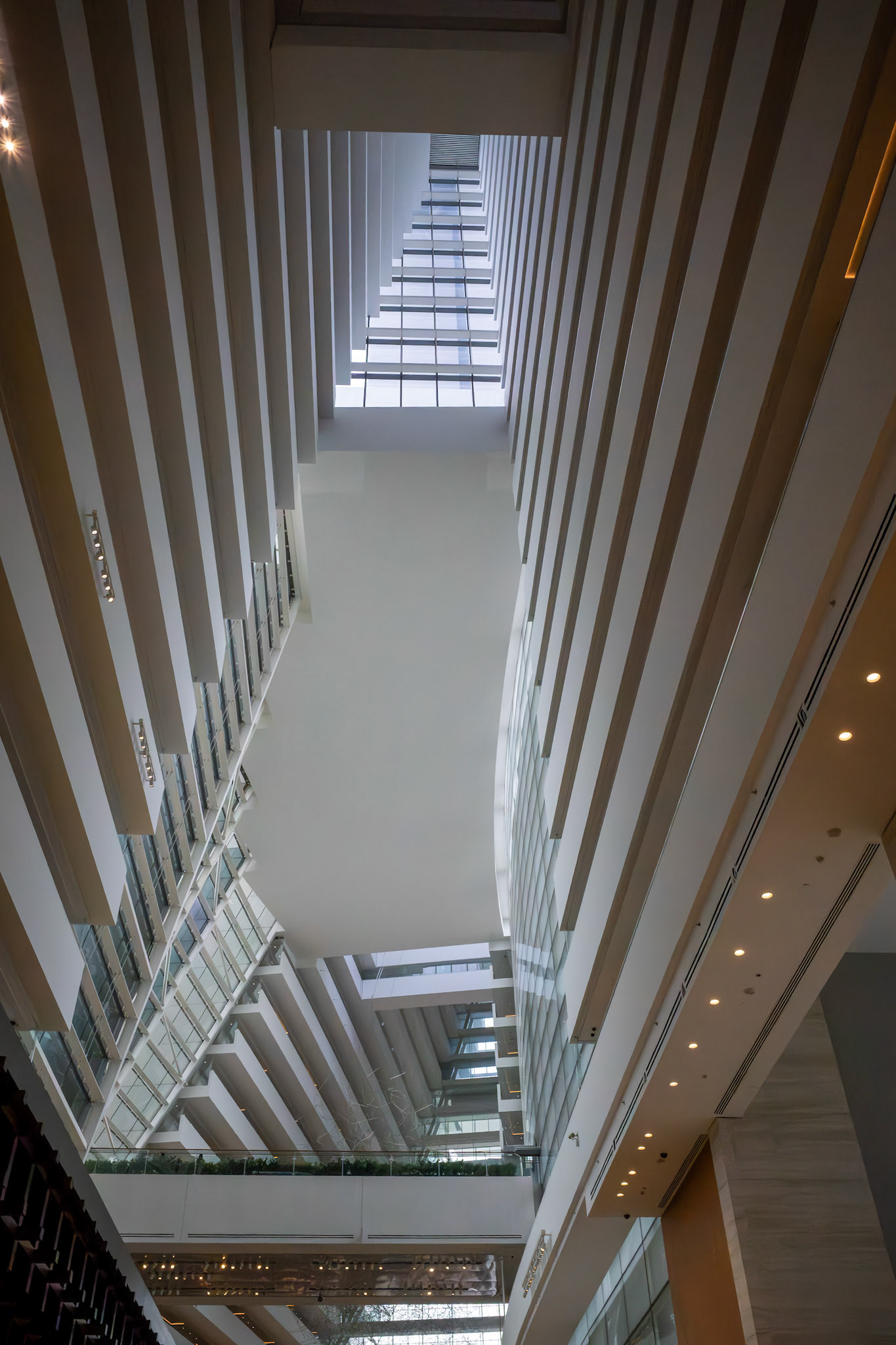 Innenansicht mit Blick nach oben durch das Atrium; zentrale Öffnung mit natürlichem Lichteinfall.