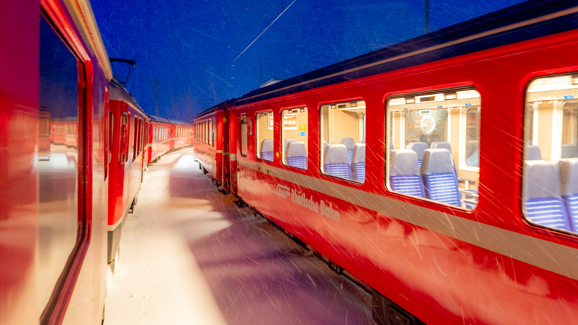 Two trains of Rhaetian Railways on the Bernina Line at Night